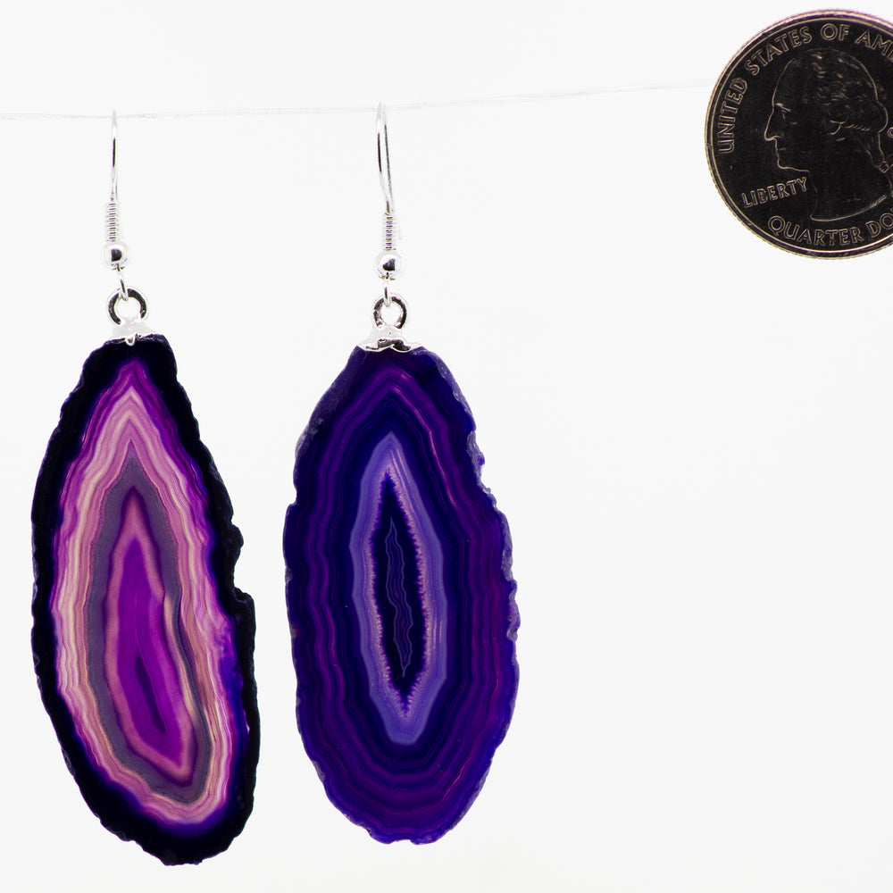 A purple Agate Slice Earrings hanging from a string, adorned with Super Silver plated french hooks.