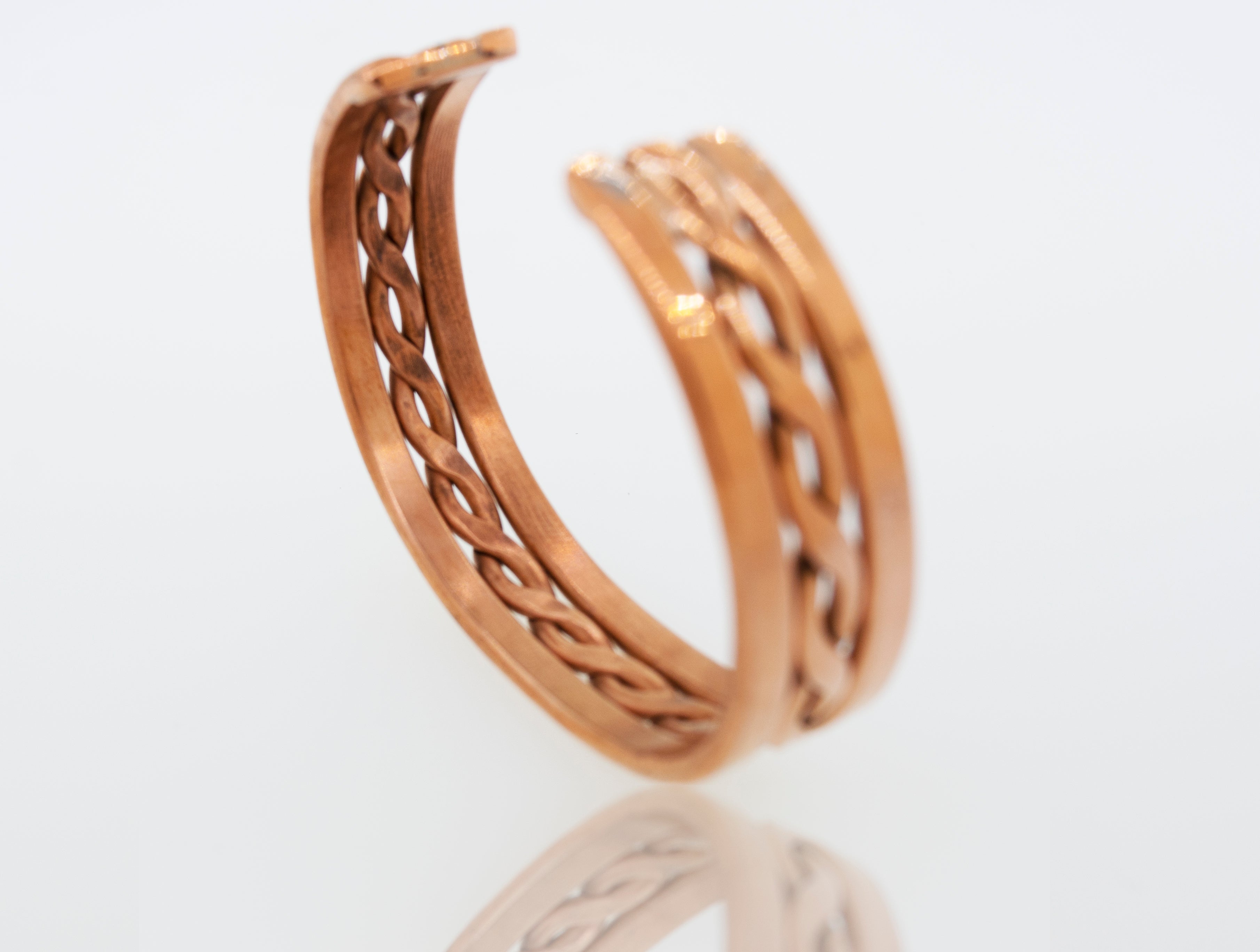 A Super Silver Native American Handmade Copper cuff bracelet on a white surface.