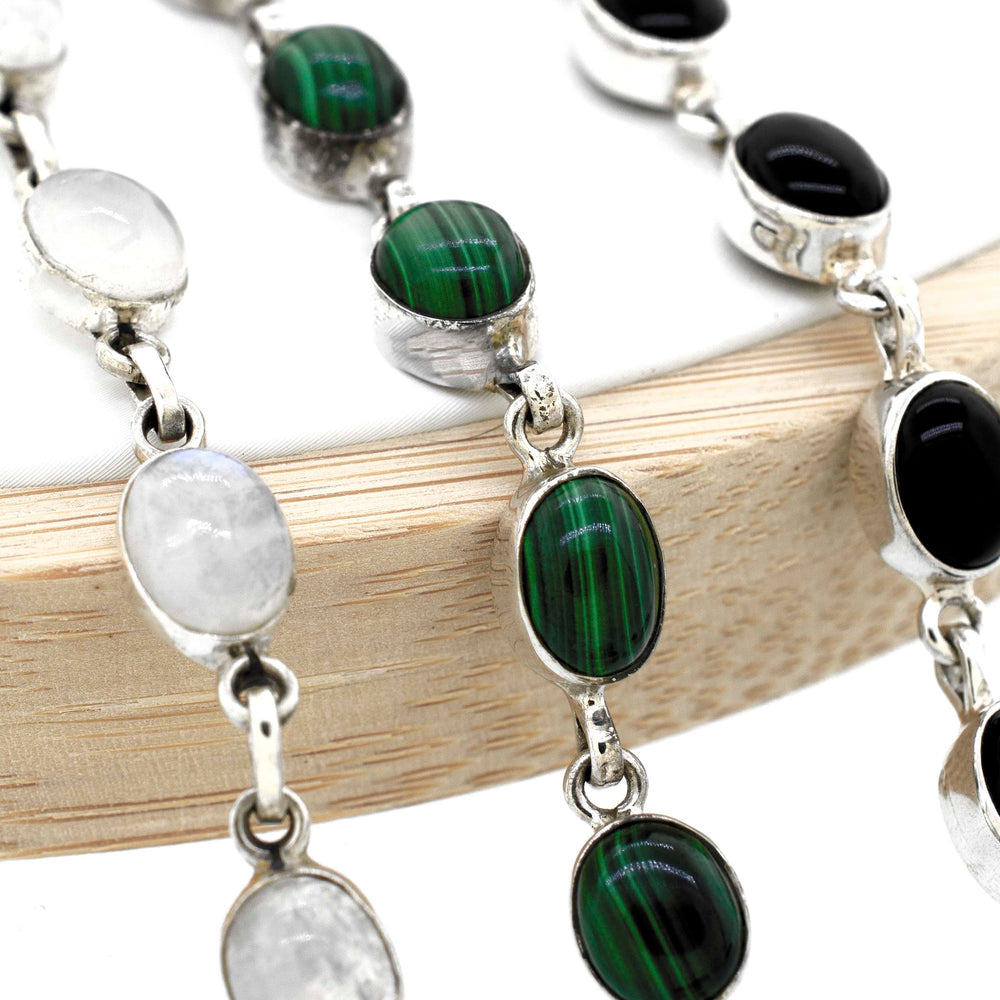 A Super Silver simple oval gemstone bracelet adorned with elegant black and white gemstones.
