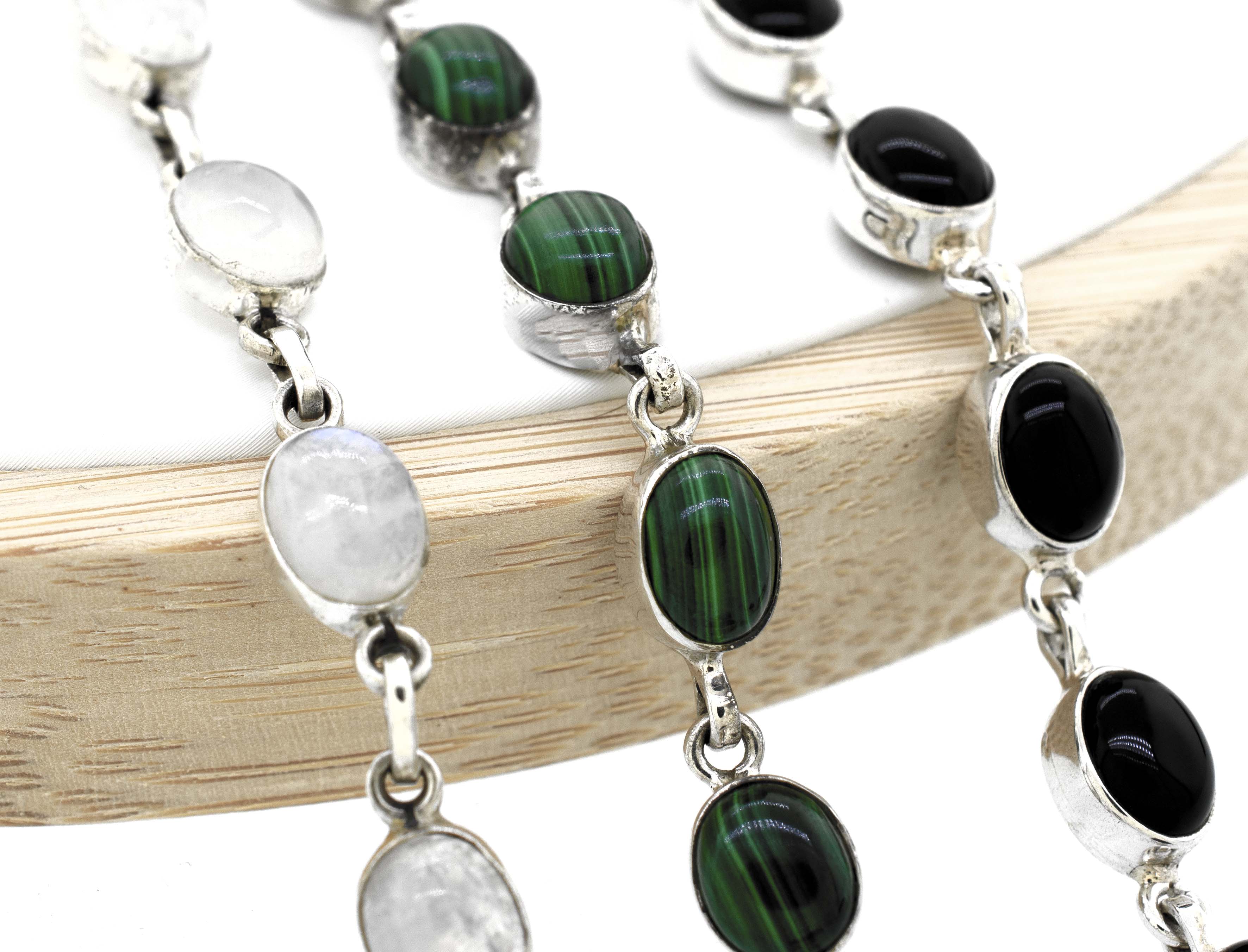 A Super Silver simple oval gemstone bracelet adorned with elegant black and white gemstones.