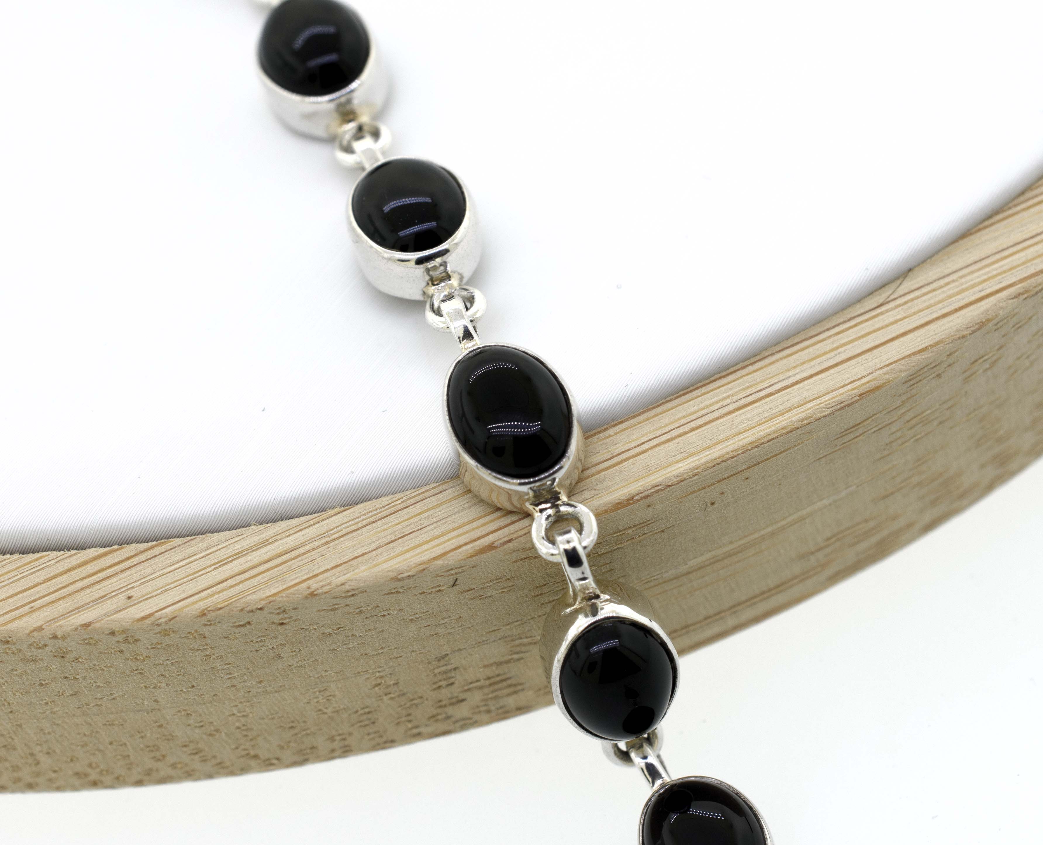 A Super Silver Simple Oval Gemstone Bracelet that combines simplicity and elegance with silver and black onyx beads.