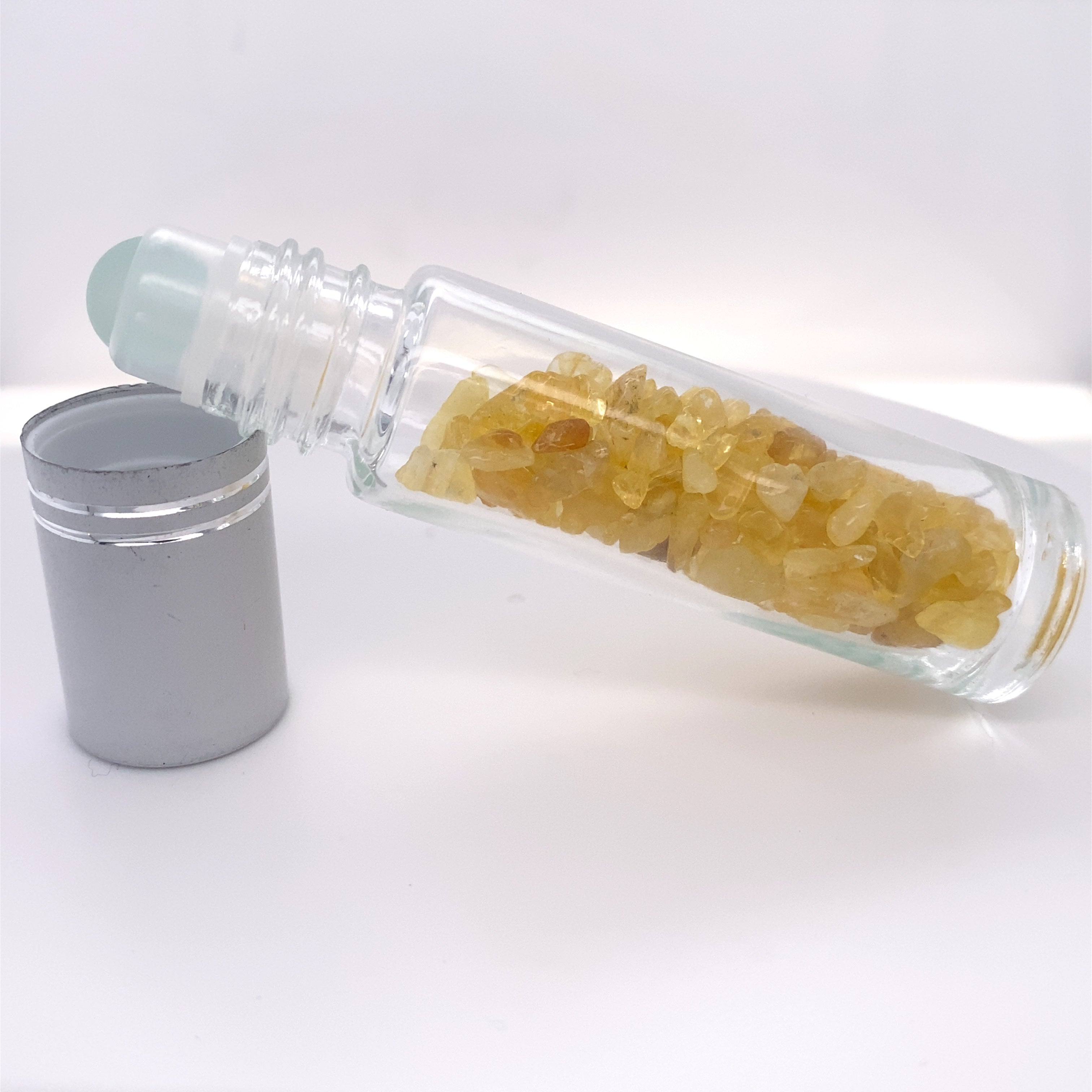 A Stone Essential Oil Roller with a yellow crystal in it.