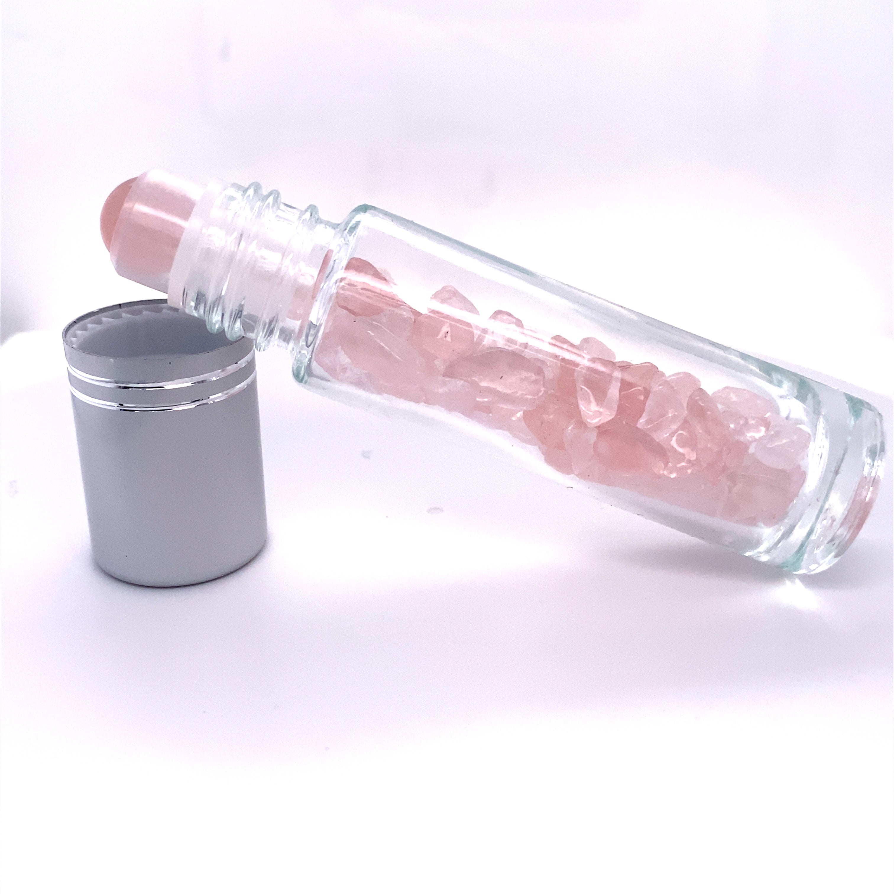 A Stone Essential Oil Roller filled with pink crystals, perfect for self care and essential oil blends.