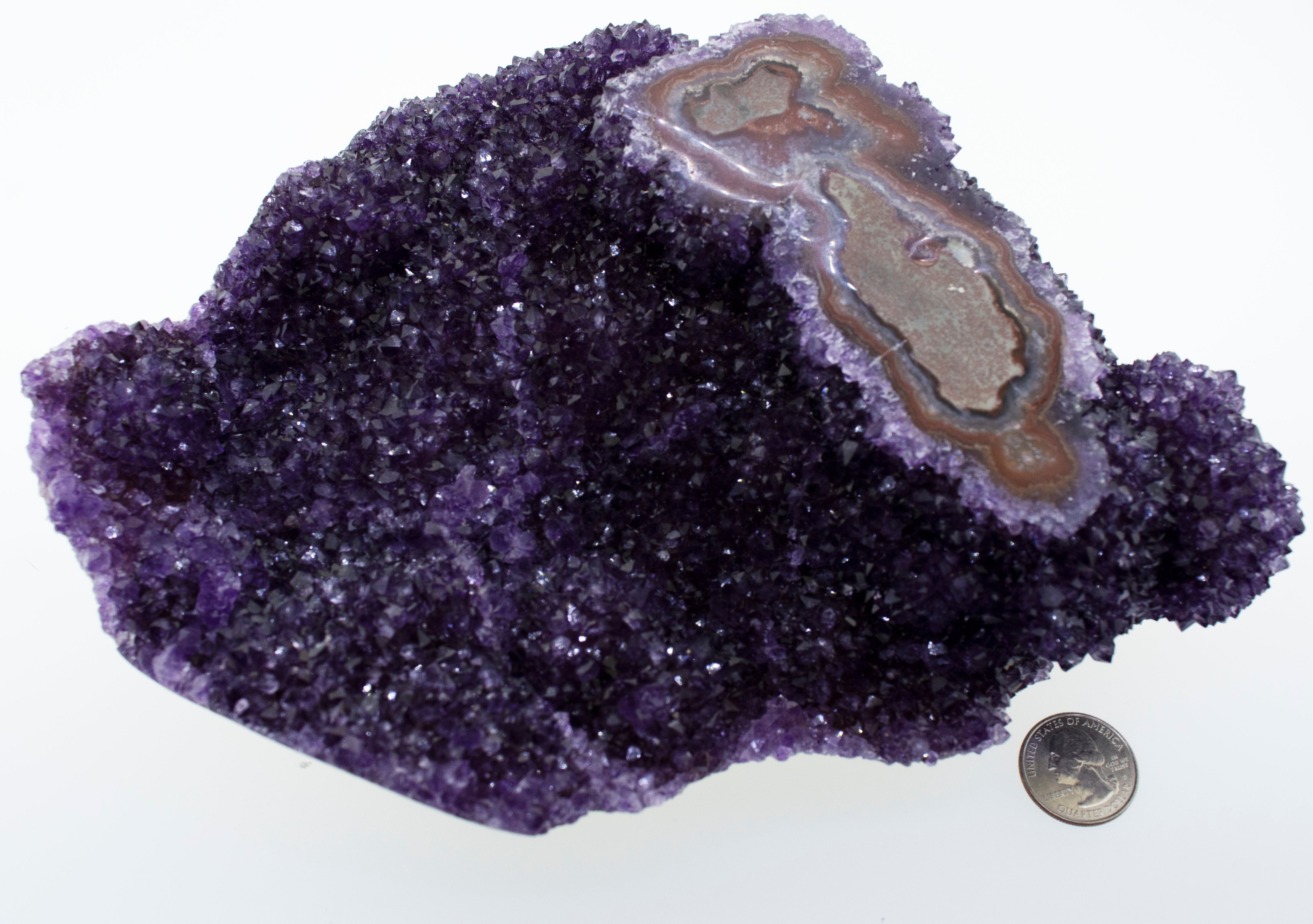 A Beautiful Freeform Amethyst Geode next to a dime.