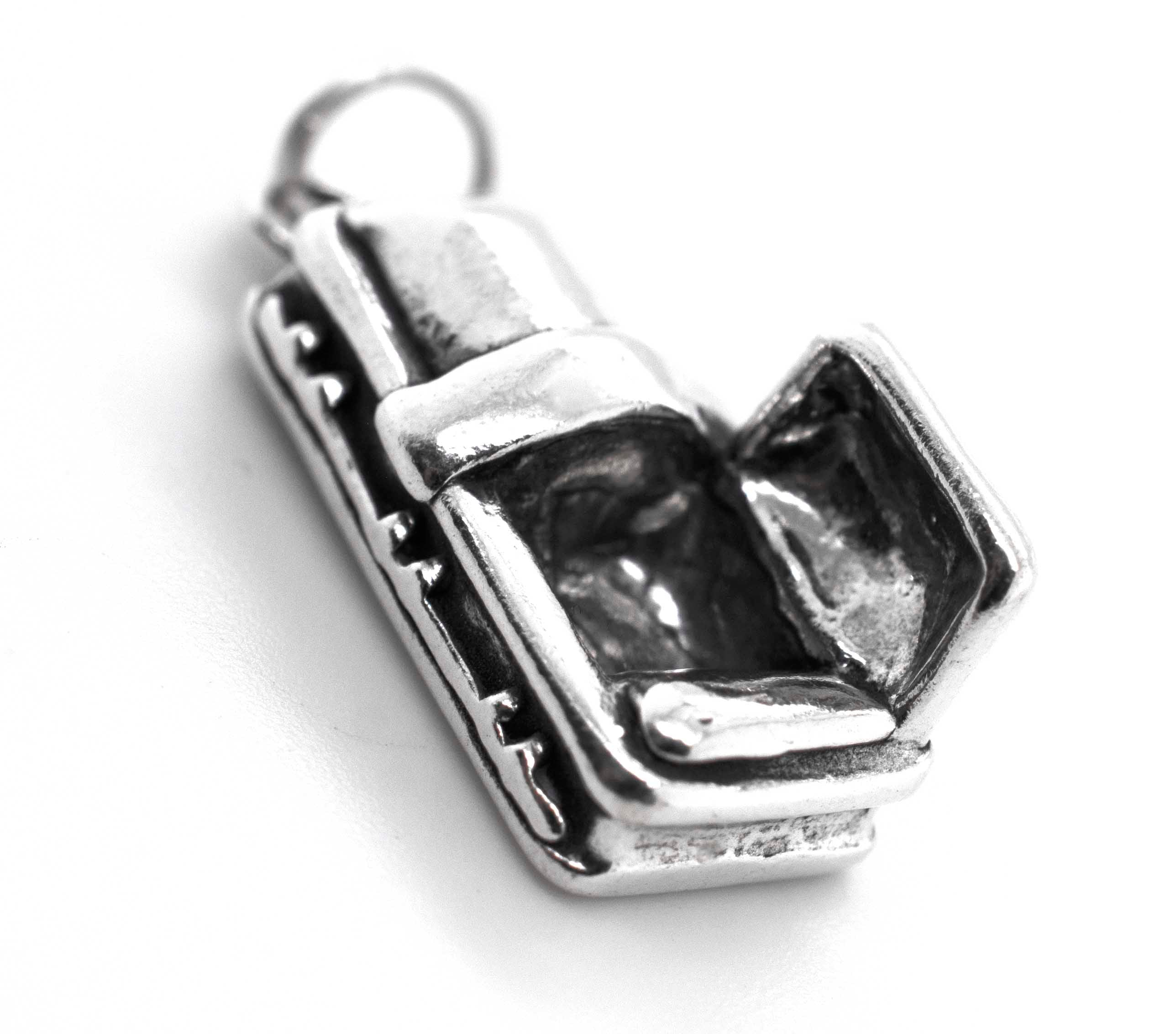 A Super Silver charm with an Open Coffin inside of it.