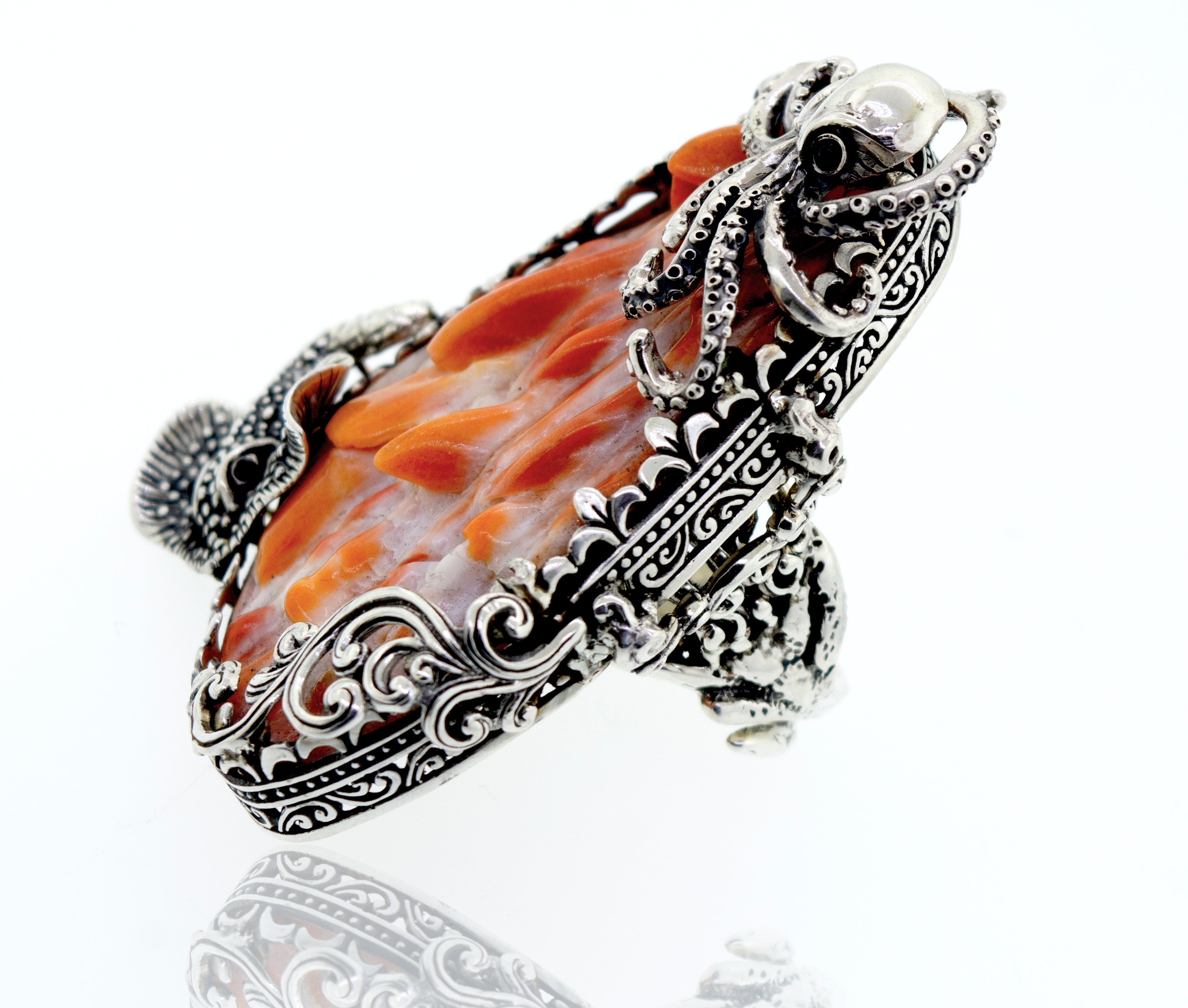 A Handcrafted Spiny Shell Designer Ring with an orange stone on a white surface.