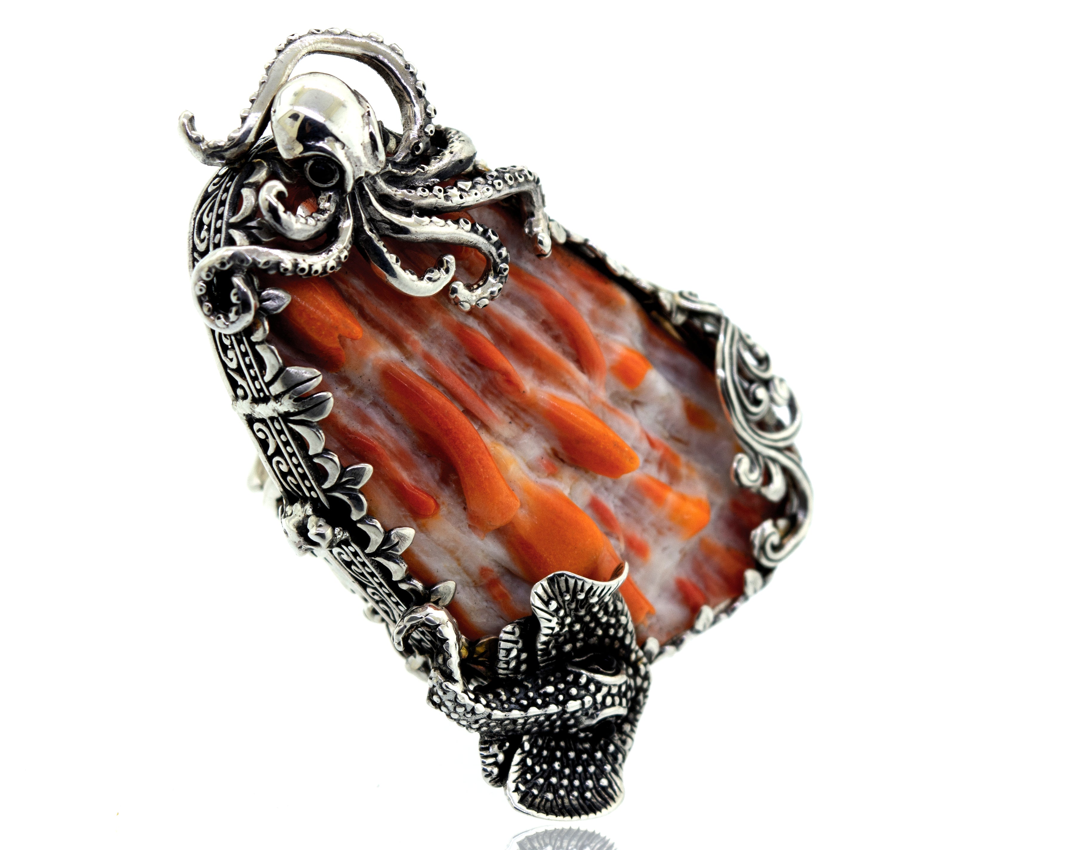 A handcrafted silver octopus pendant with an orange spiny oyster shell stone.