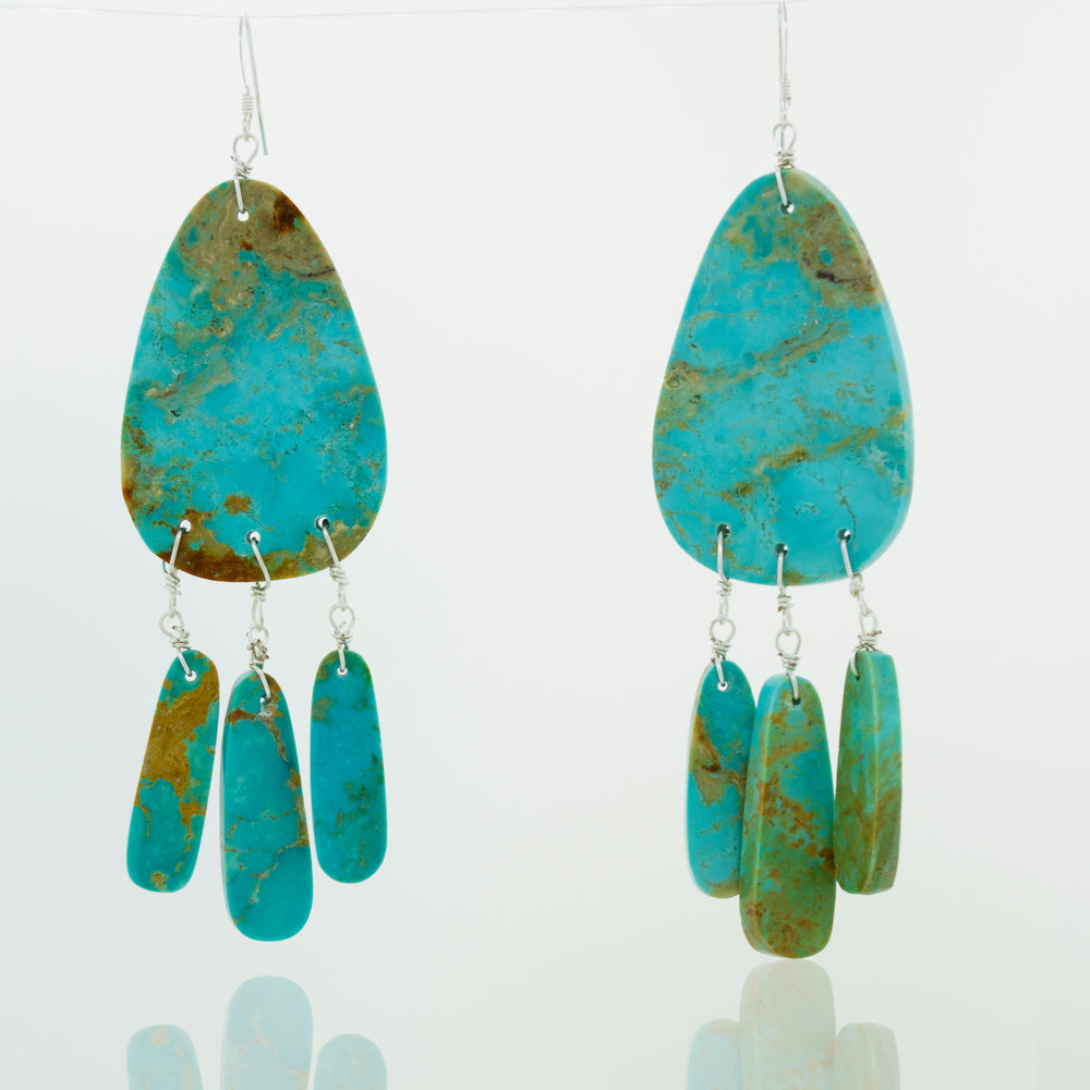 A pair of Super Silver Native American Raw Turquoise Earrings on a white background.