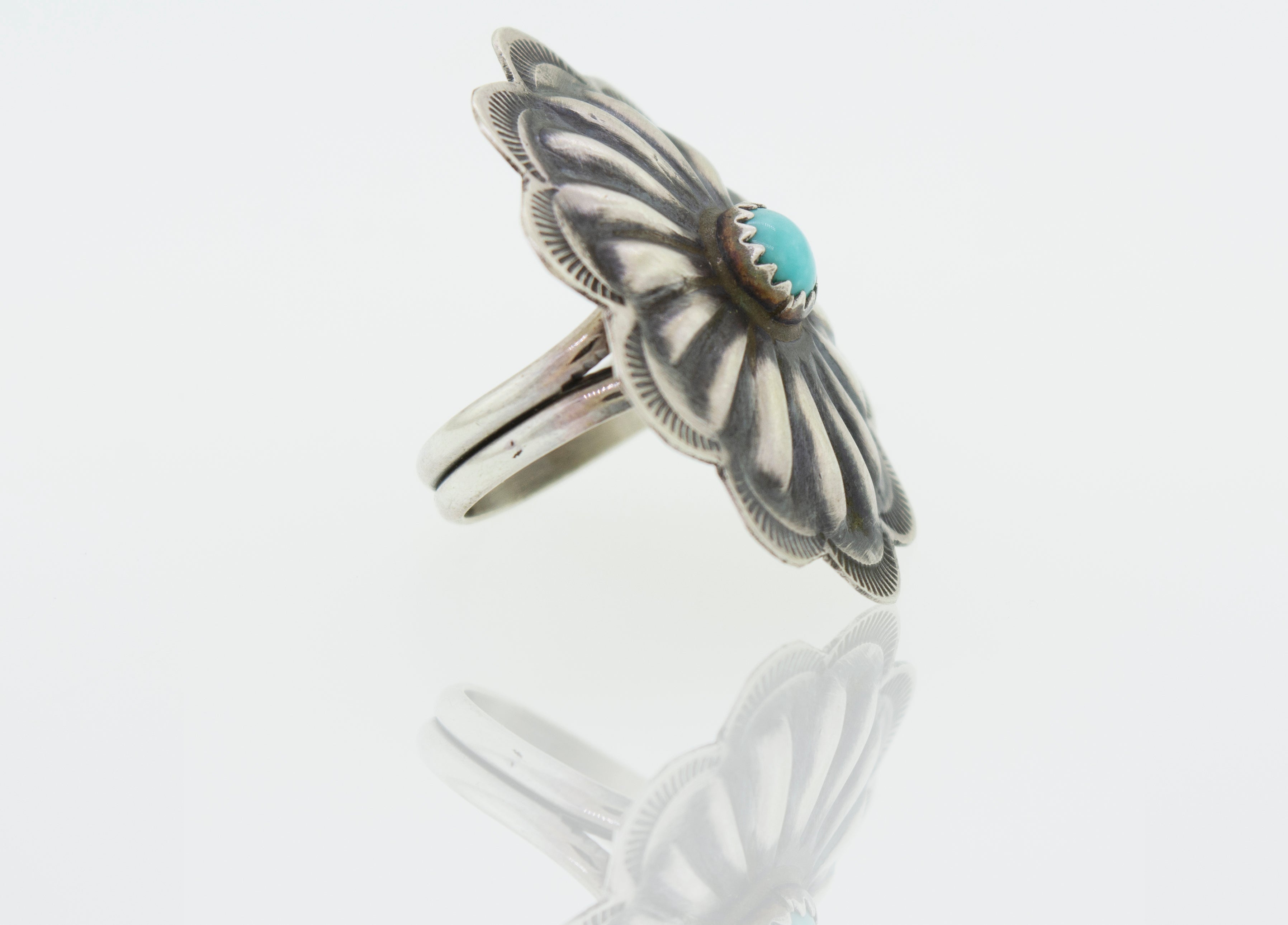 A Native American Turquoise Flower Ring with a turquoise stone.
