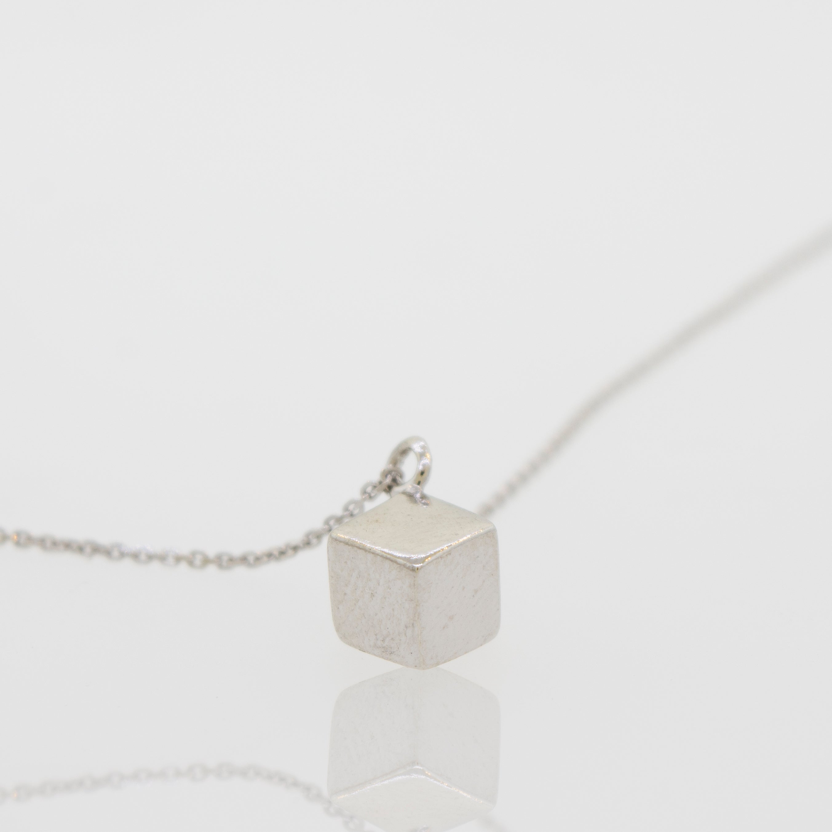 A Super Silver sleek three-dimensional silver cube necklace.