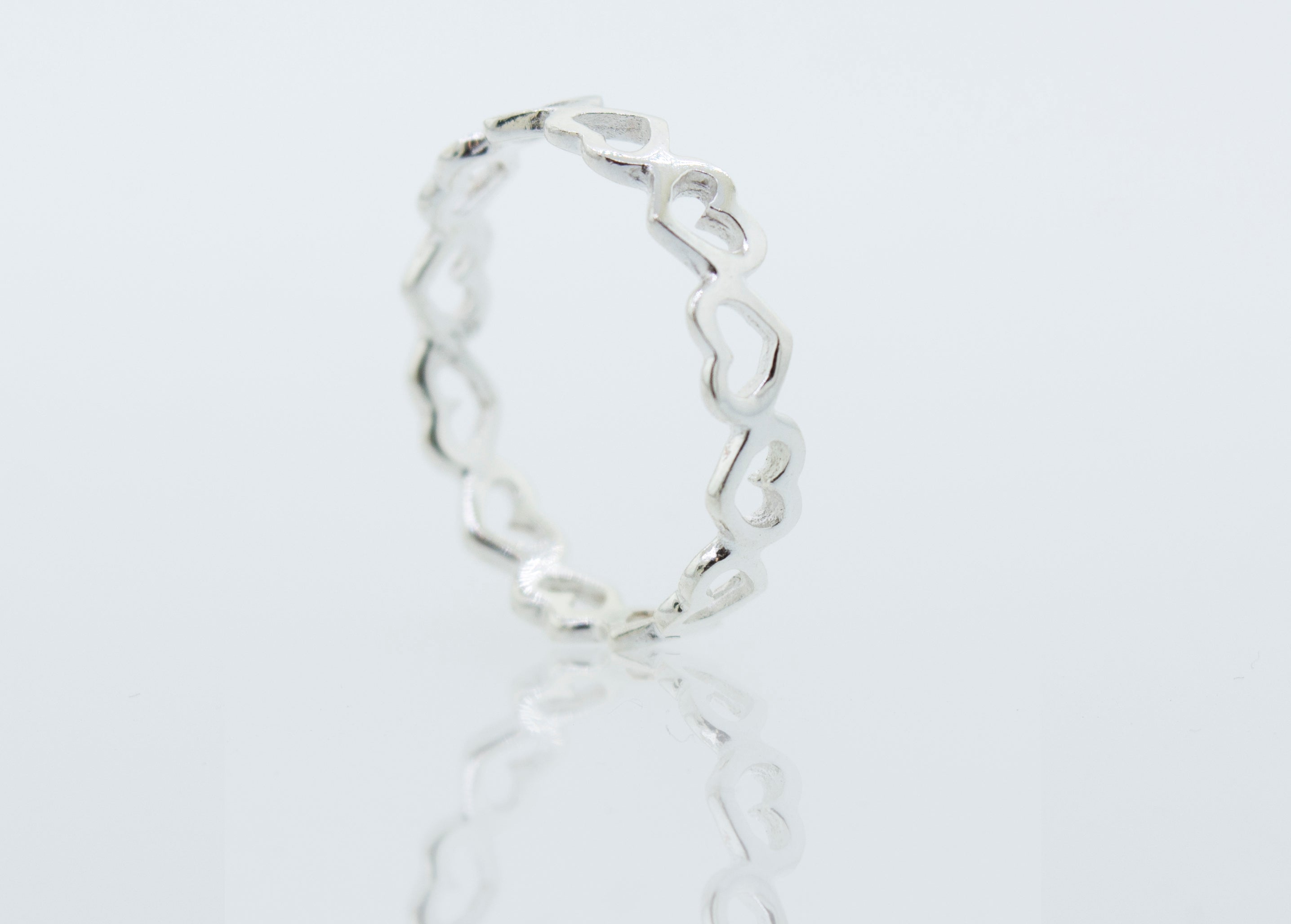 A silver Open Heart Band Ring with a twisted design, symbolizing love and adorned with a heartfelt touch.