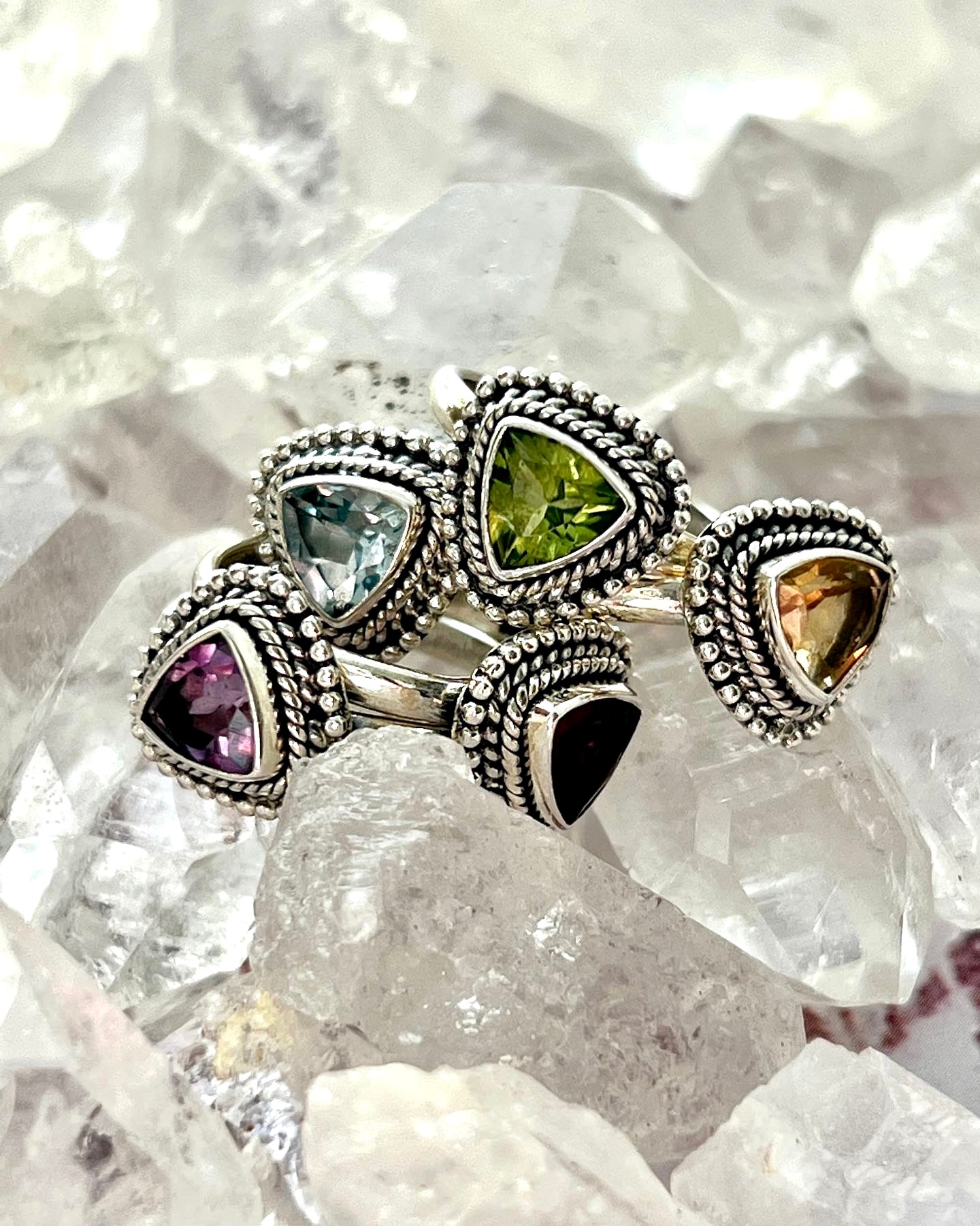 A stack of Triangle Gemstone Rings with Rope Border adorned with vibrant cabochon stones.