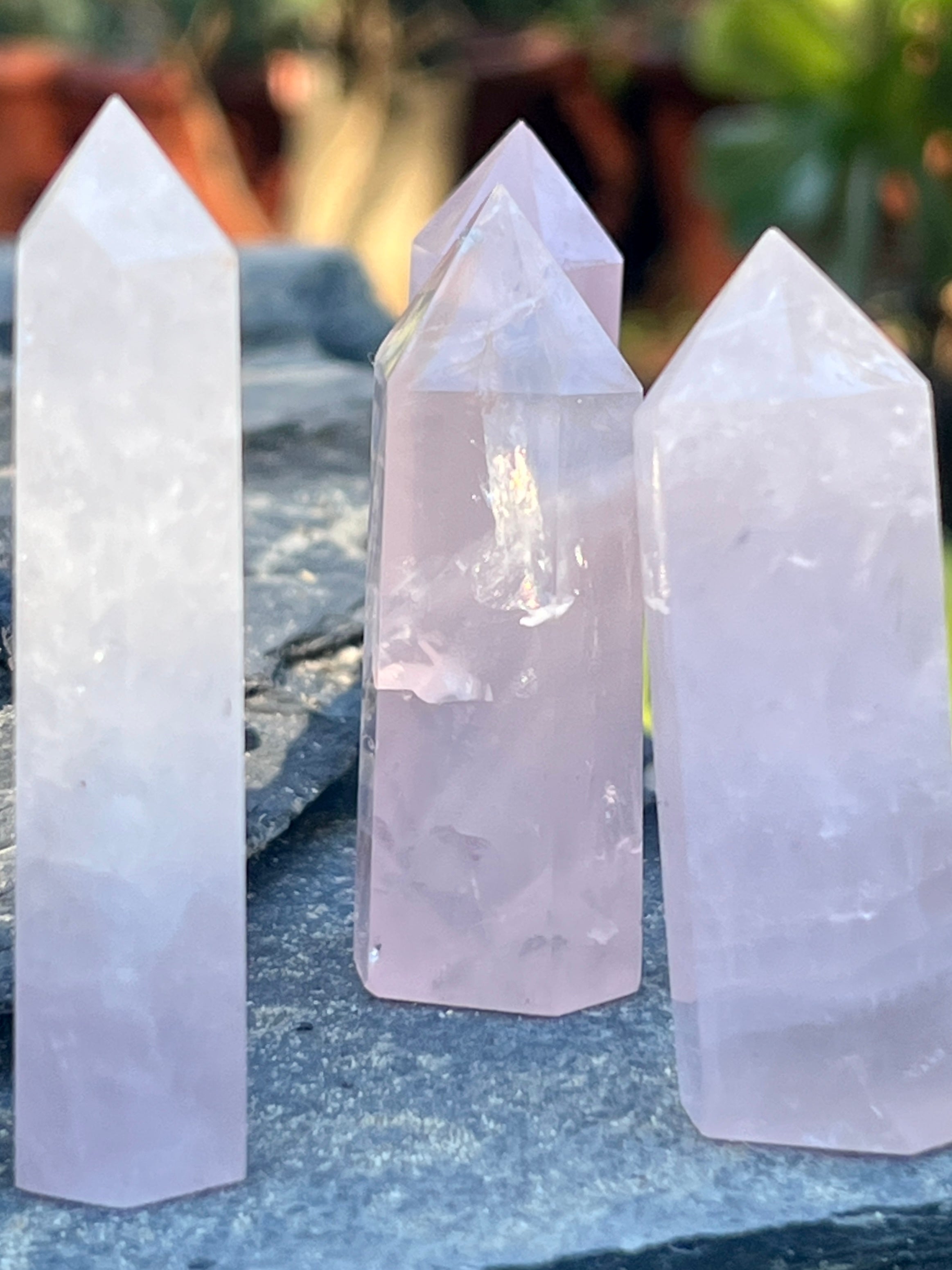 Three Rose Quartz Obelisks on a rock.