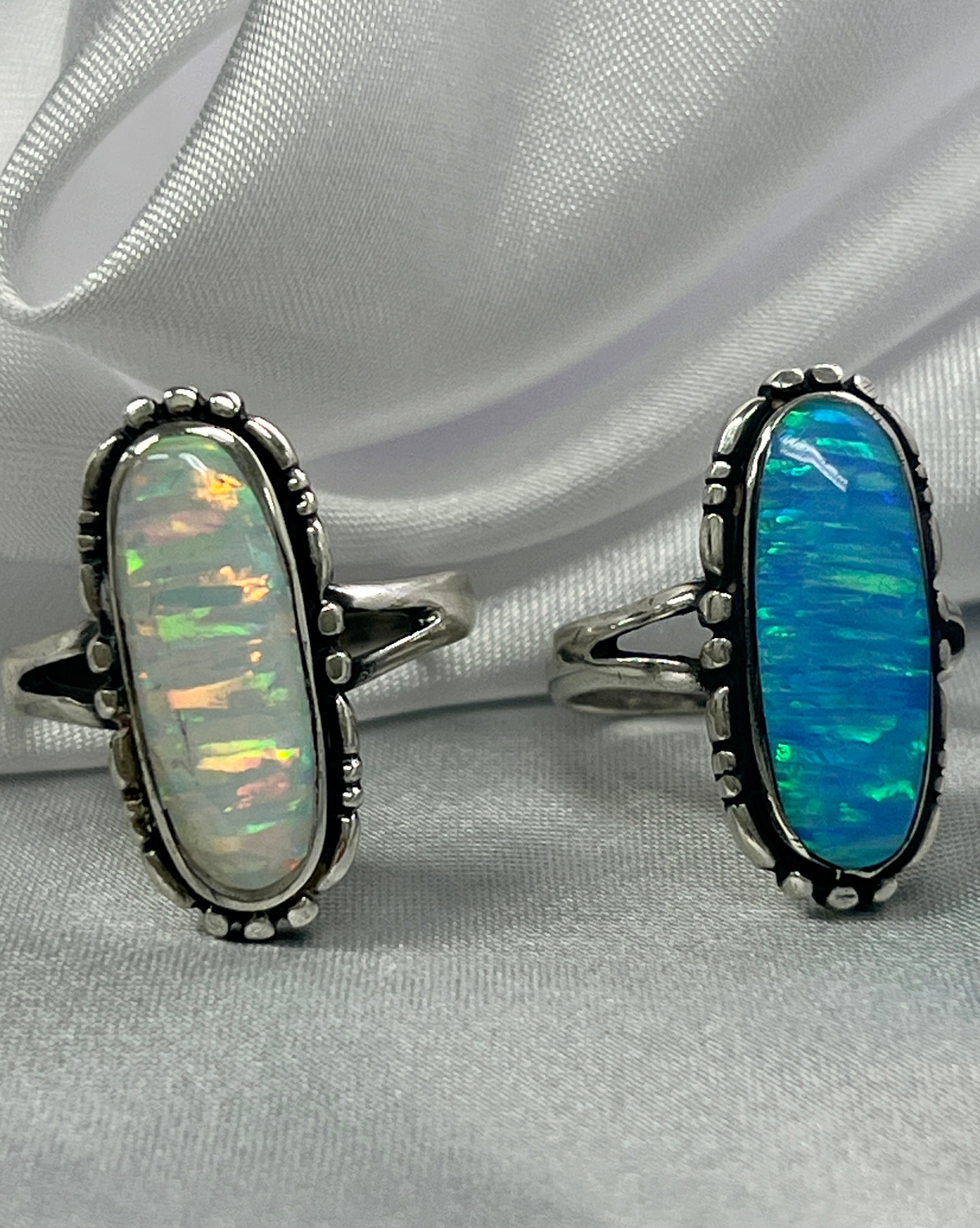 Two American Made Oval Opal Rings by Super Silver on a white cloth.