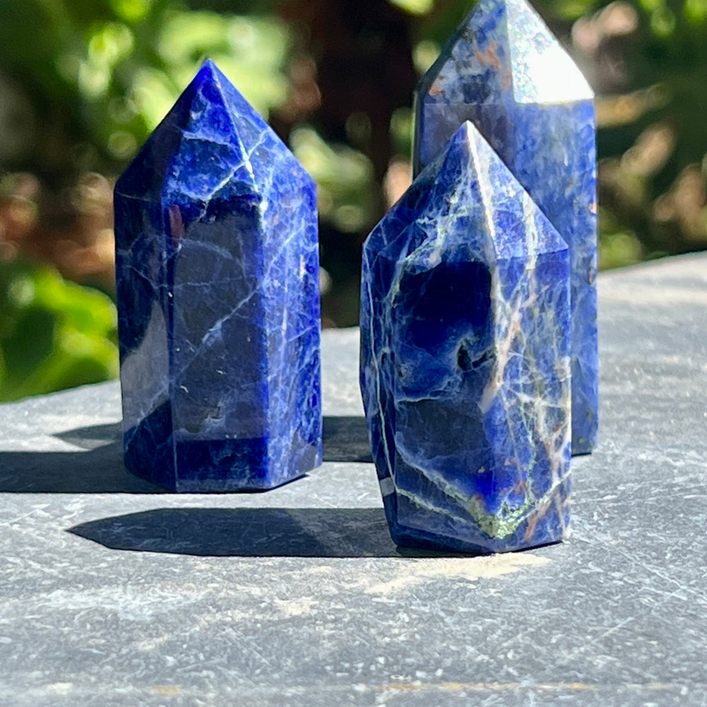 Three blue Sodalite Obelisks on a table.