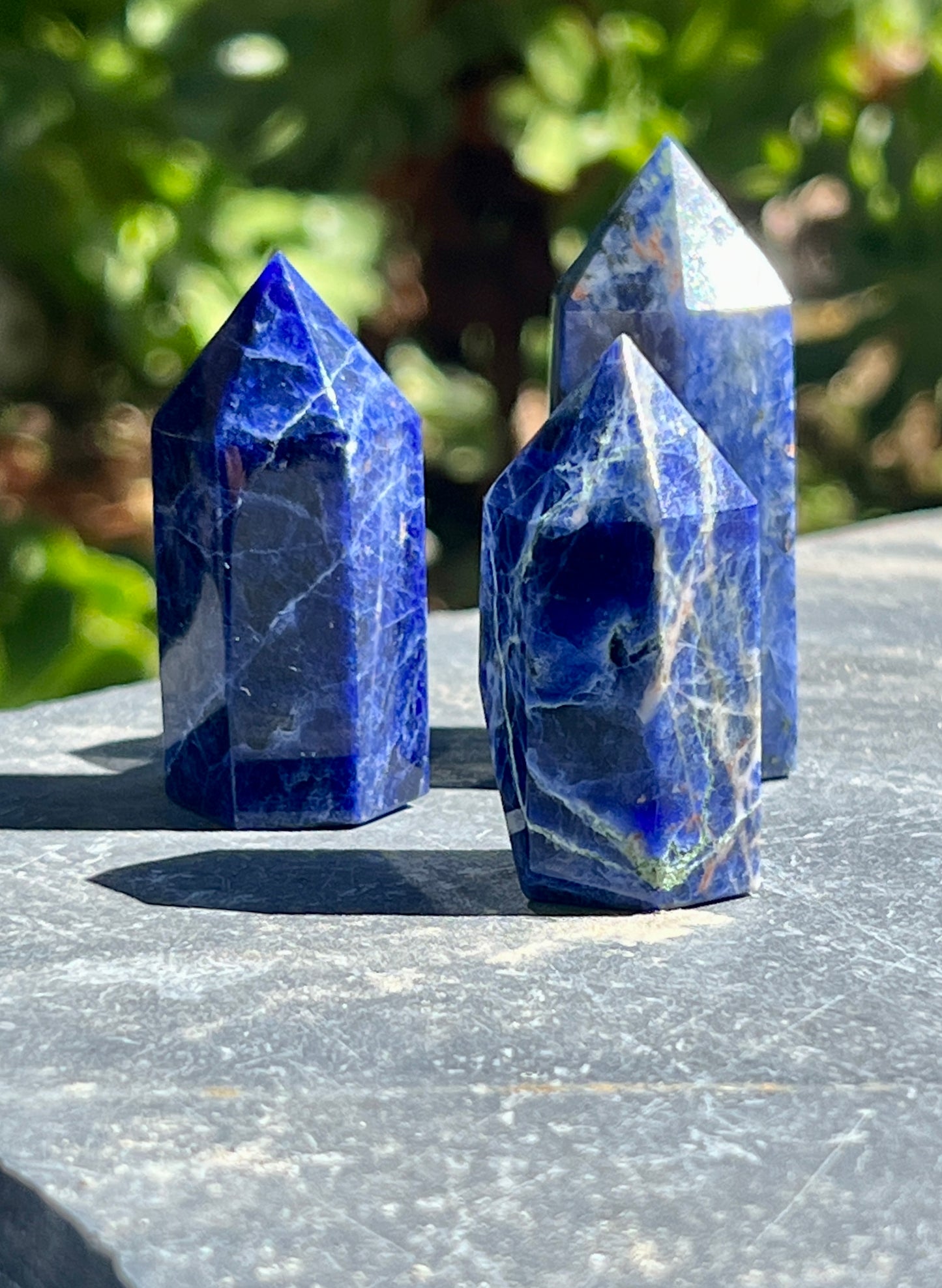 Three blue Sodalite Obelisks on a table.