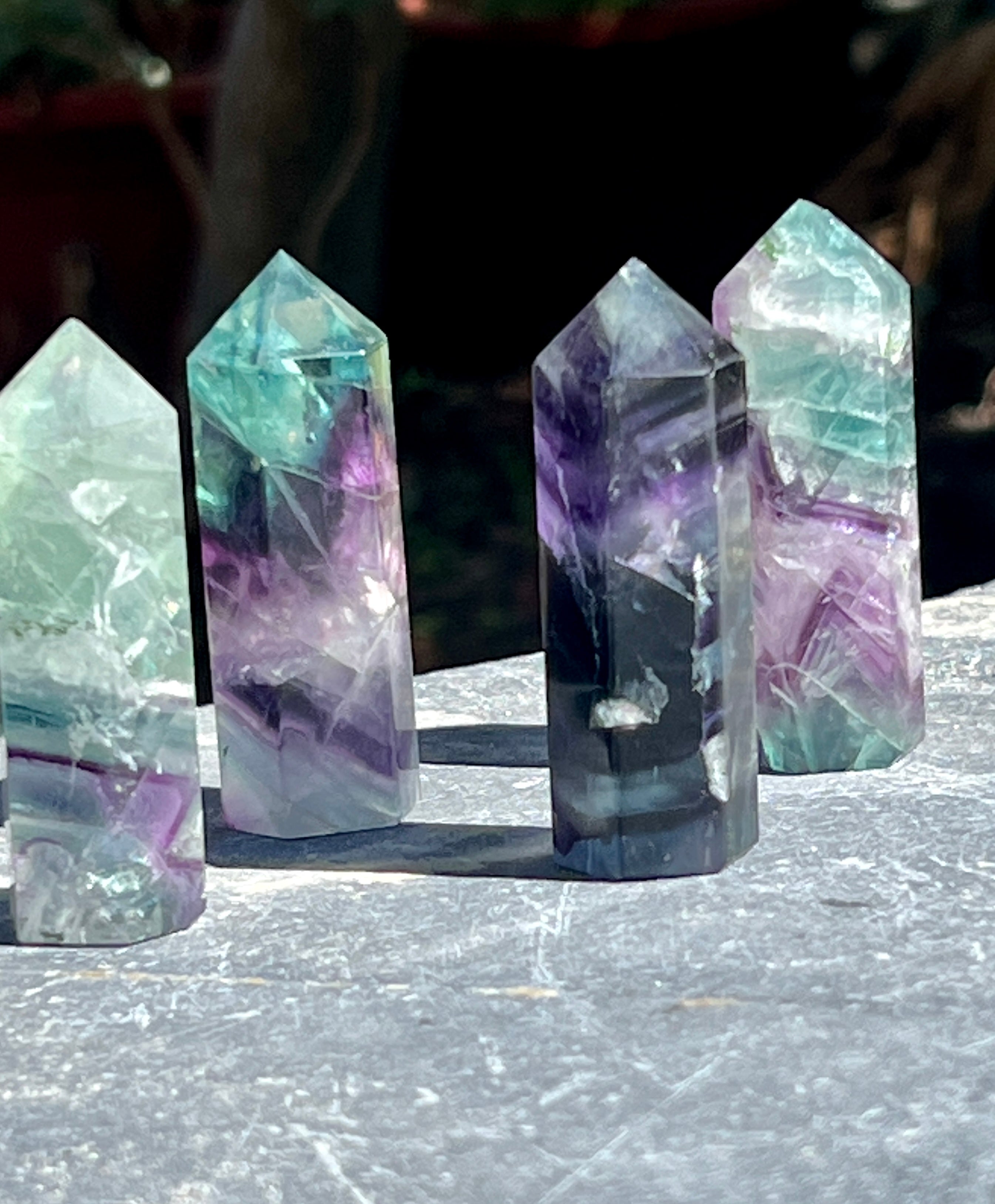 A Rainbow Fluorite Obelisk on a table.
