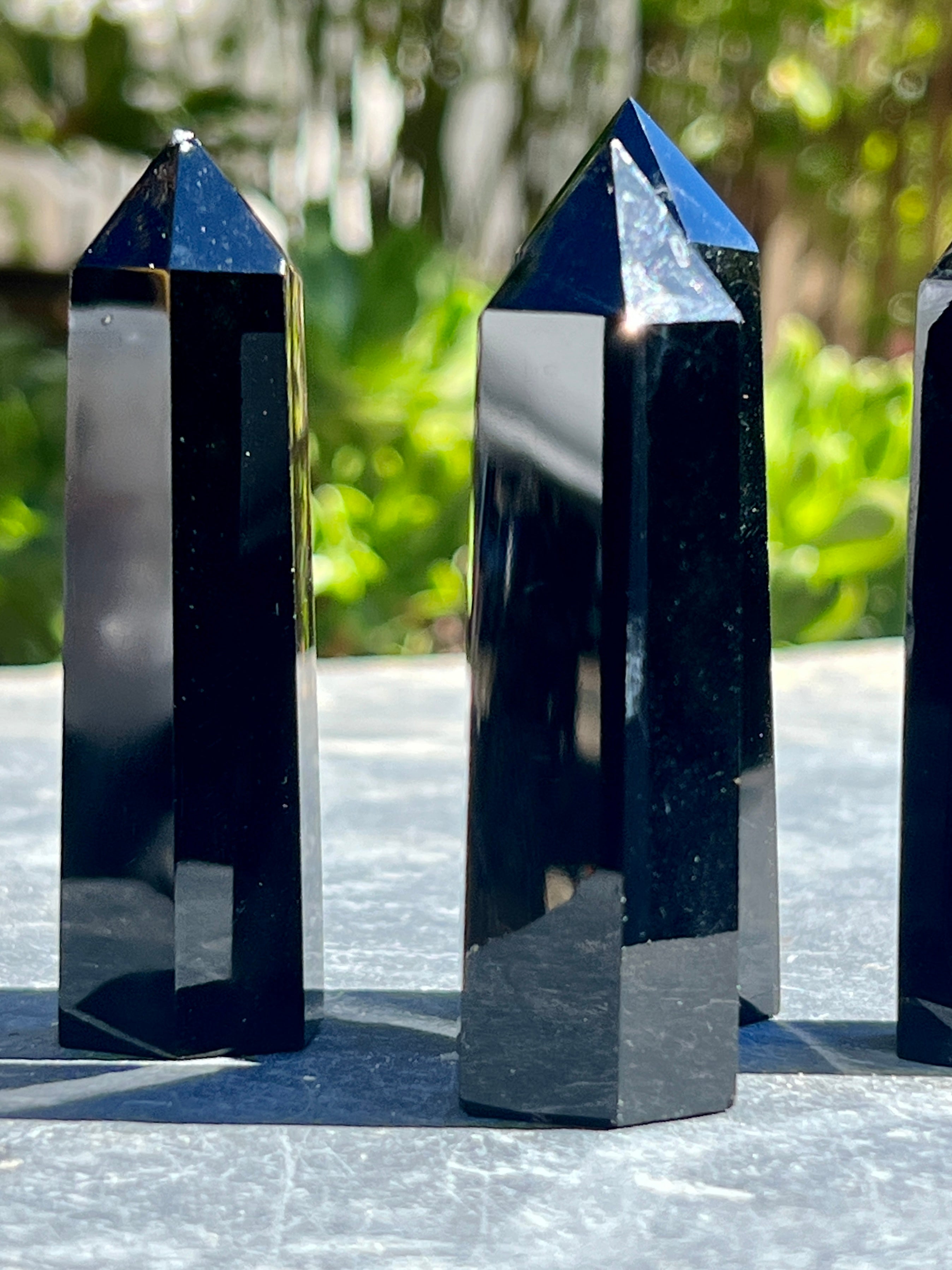 Three gothic Black Obsidian Obelisks sitting on a table.