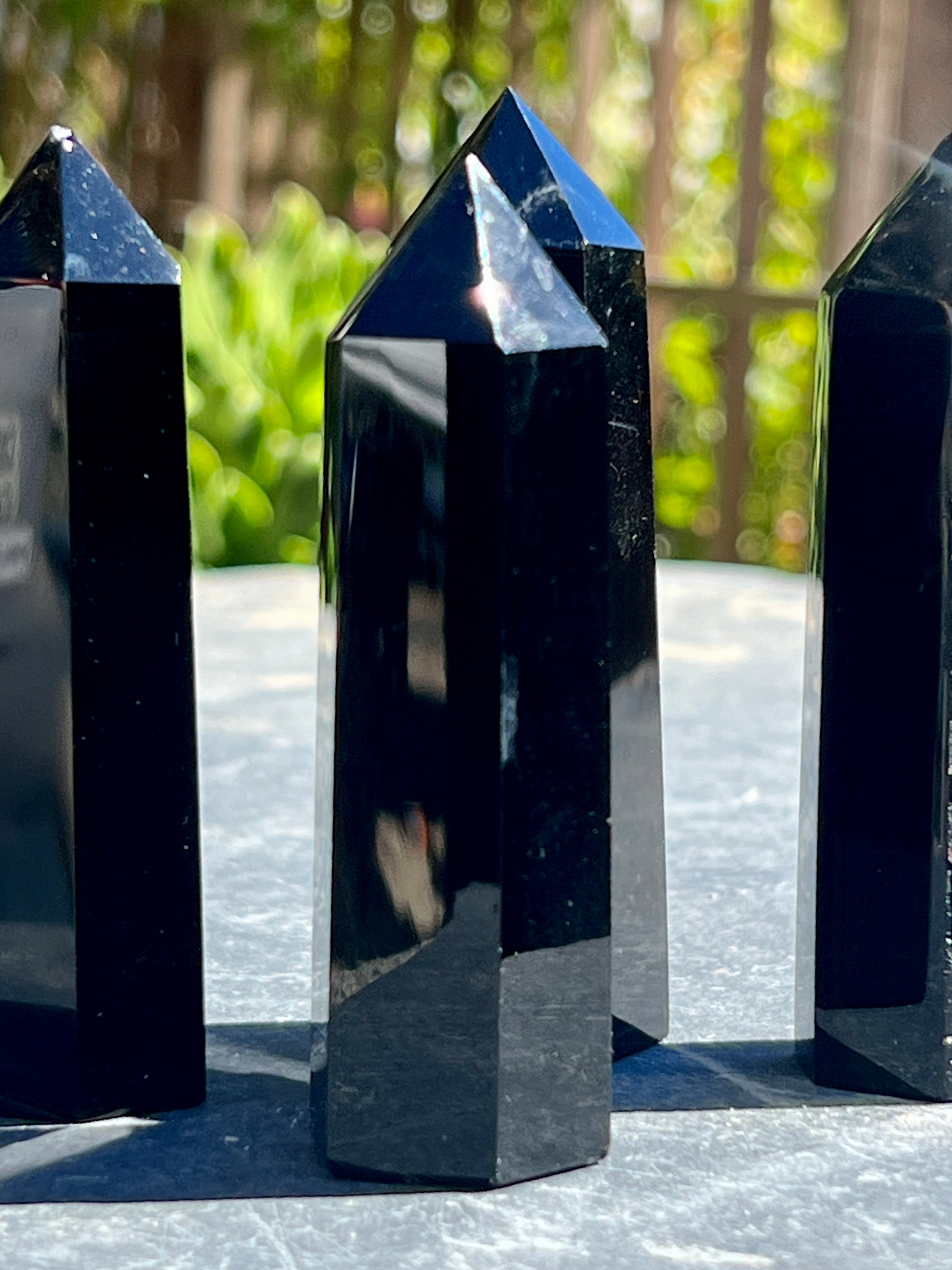 Three Black Obsidian Obelisks used as decor sitting on a table.