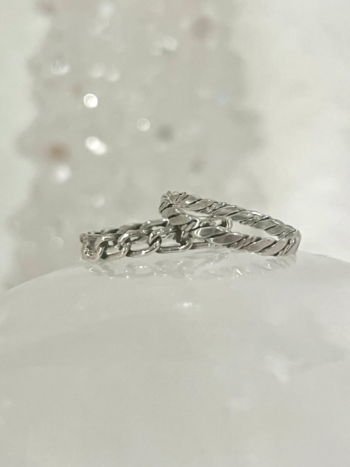 
                  
                    Two Dainty Twisted Rope Band Rings, with a rustic allure and vintage vibe, sitting on top of a piece of snow. (Super Silver)
                  
                