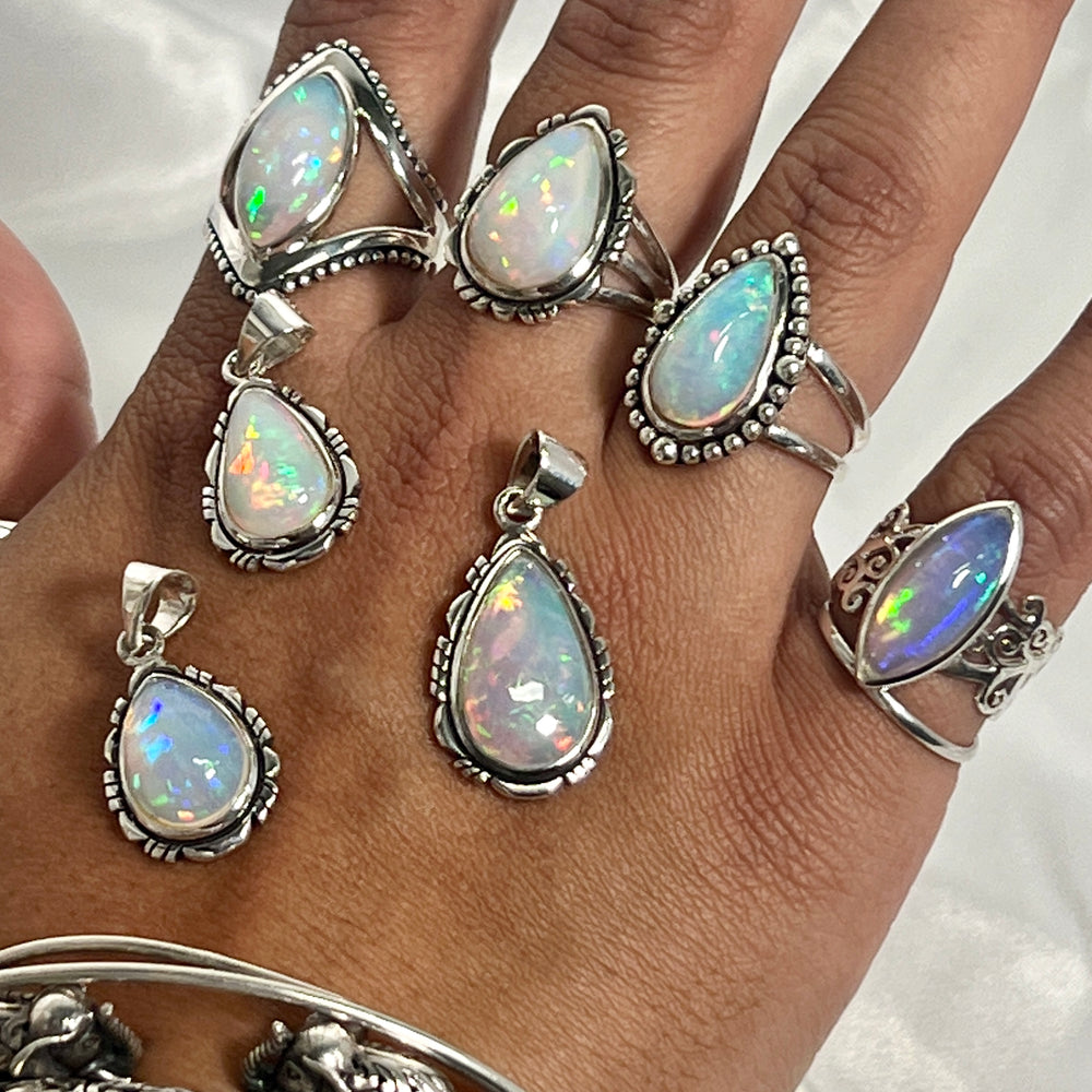 
                  
                    A woman's hand adorned with a stunning Super Silver Ethiopian Opal Teardrop Shaped Pendant with Detailed Setting, a true statement piece of jewelry.
                  
                
