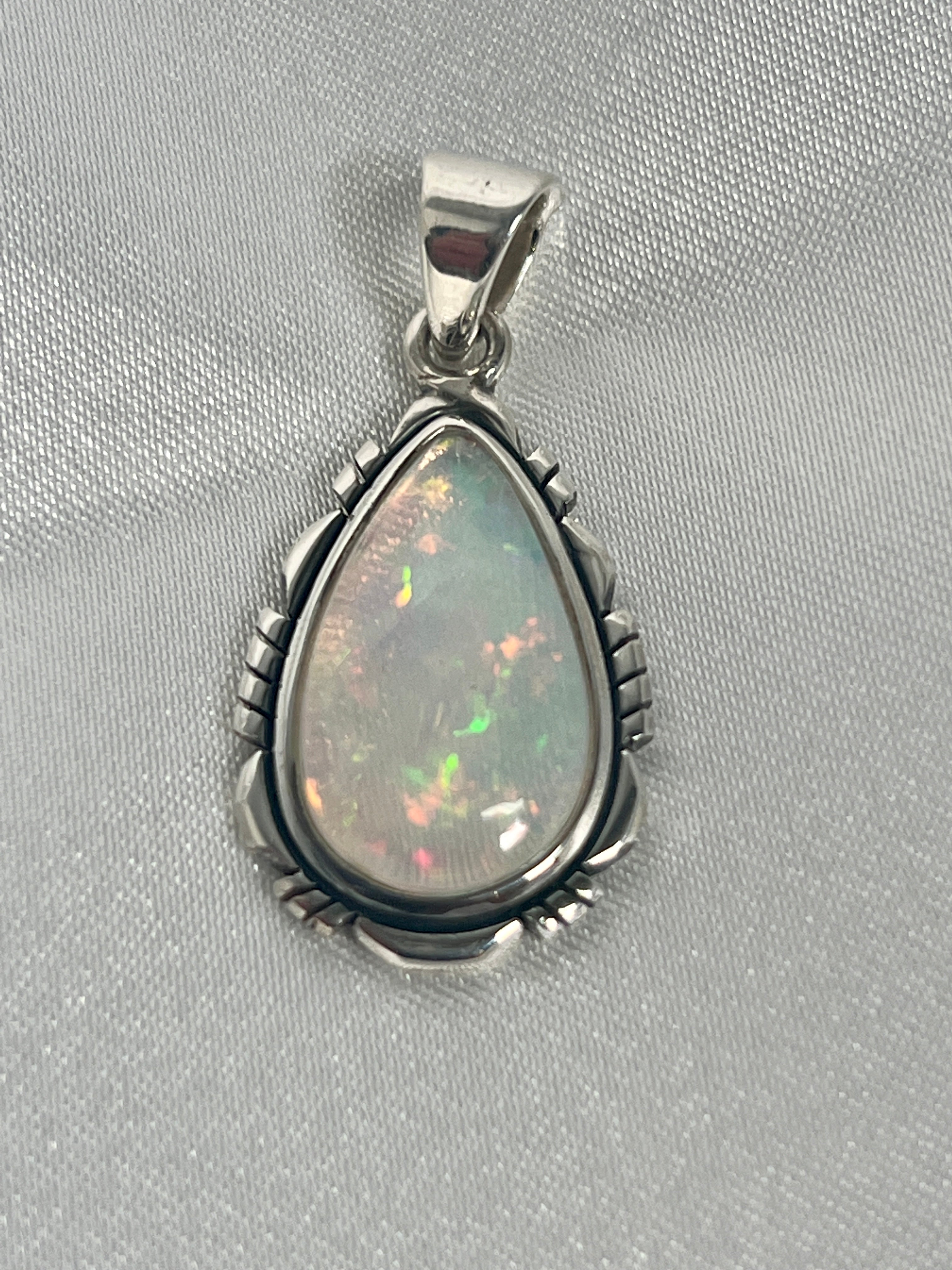 A Super Silver statement piece pendant featuring a stunning Ethiopian Opal Teardrop Shaped Pendant with Detailed Setting.