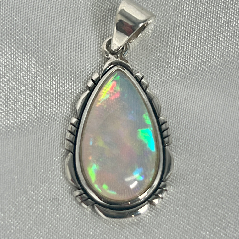 A Super Silver statement pendant featuring a brilliant Ethiopian Opal Teardrop Shaped Pendant with Detailed Setting, set in sterling silver.