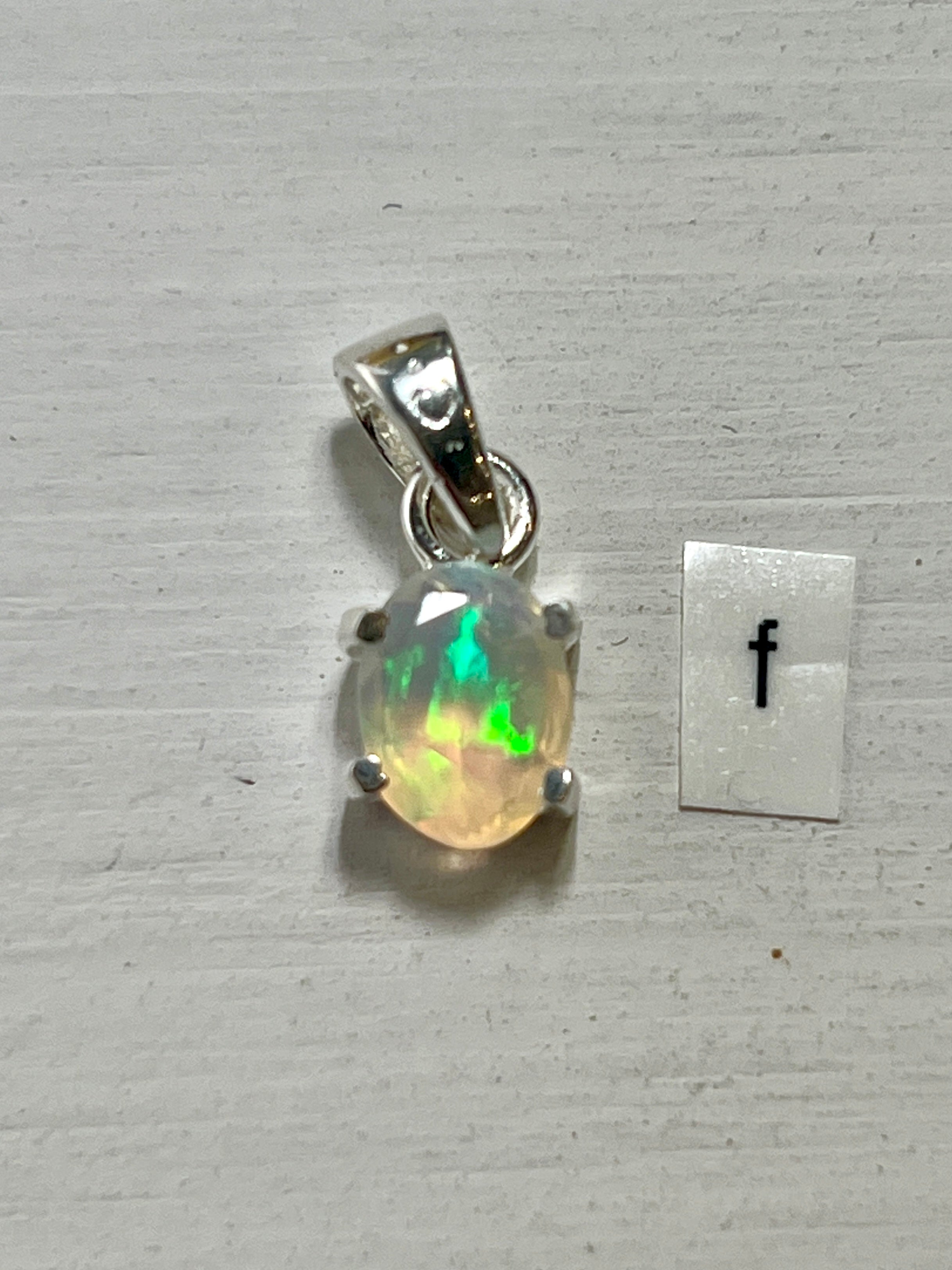 A Super Silver Tiny Facet Cut Prong Set Ethiopian Opal Pendant featuring a delicate Ethiopian opal in vibrant green.