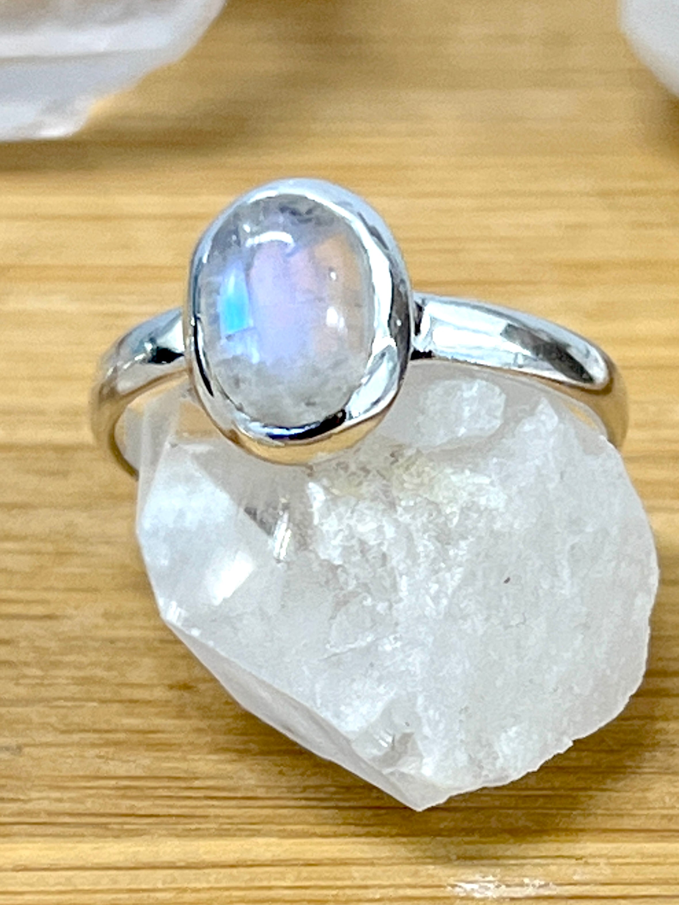 A sterling silver Simple Oval Moonstone Or Labradorite ring with a minimalist design featuring a moonstone atop a rock.
