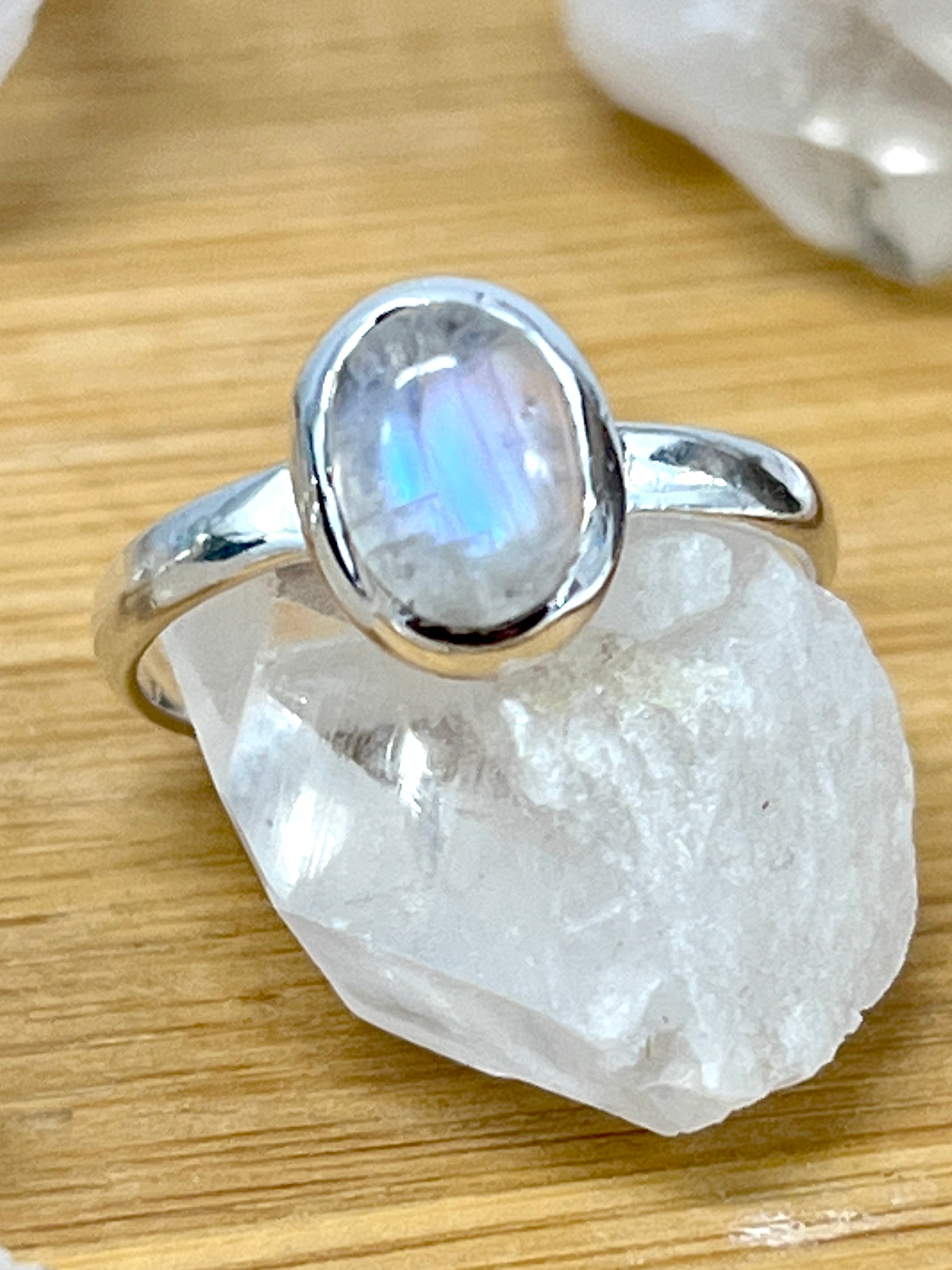 A teardrop-shaped Simple Oval Moonstone Or Labradorite engagement ring with a moonstone on top.