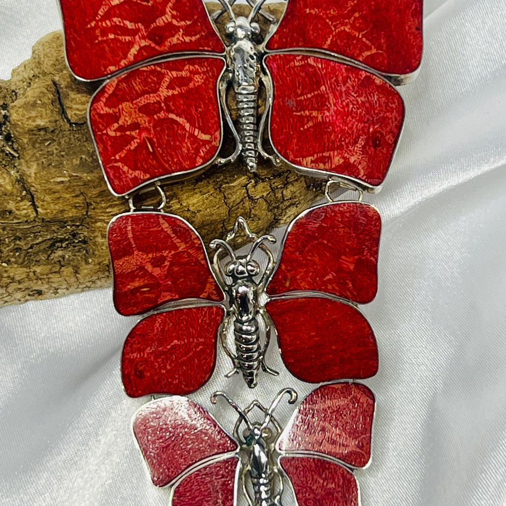 
                  
                    A red and silver Super Silver butterfly brooch, the Statement Pendant/ Brooch with Three Butterflies, on a white background.
                  
                