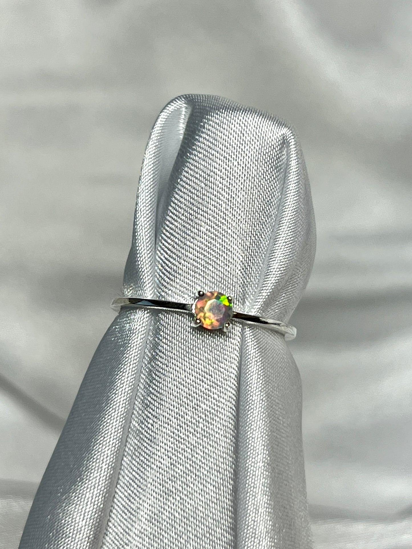 Dainty Prong Set Facet Cut Ethiopian Opal Ring" is an elegant silver ring featuring an opal stone, perfect for engagements.