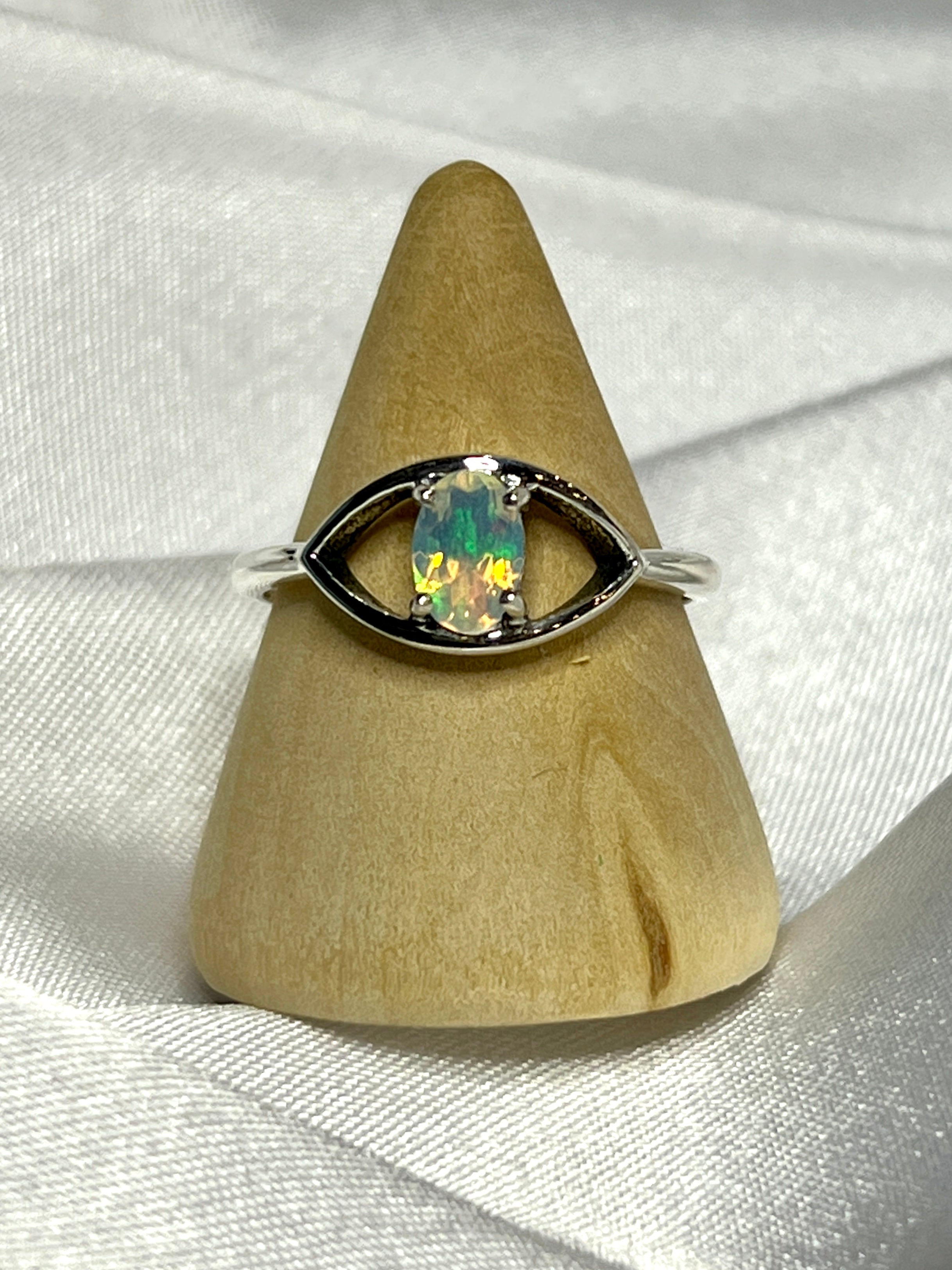 An elegant Facet Cut Ethiopian Opal Evil Eye Ring on a white background.