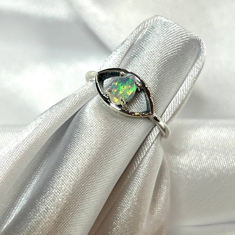 An Facet Cut Ethiopian Opal Evil Eye Ring adorned with an Ethiopian opal, delicately placed on a pristine white cloth.
