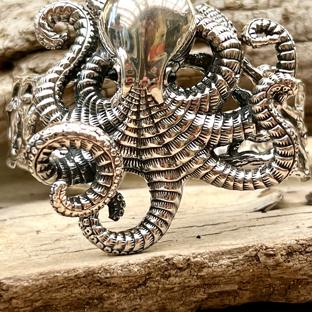 
                  
                    A Super Silver Octopus Statement Bracelet adorned on a piece of wood.
                  
                