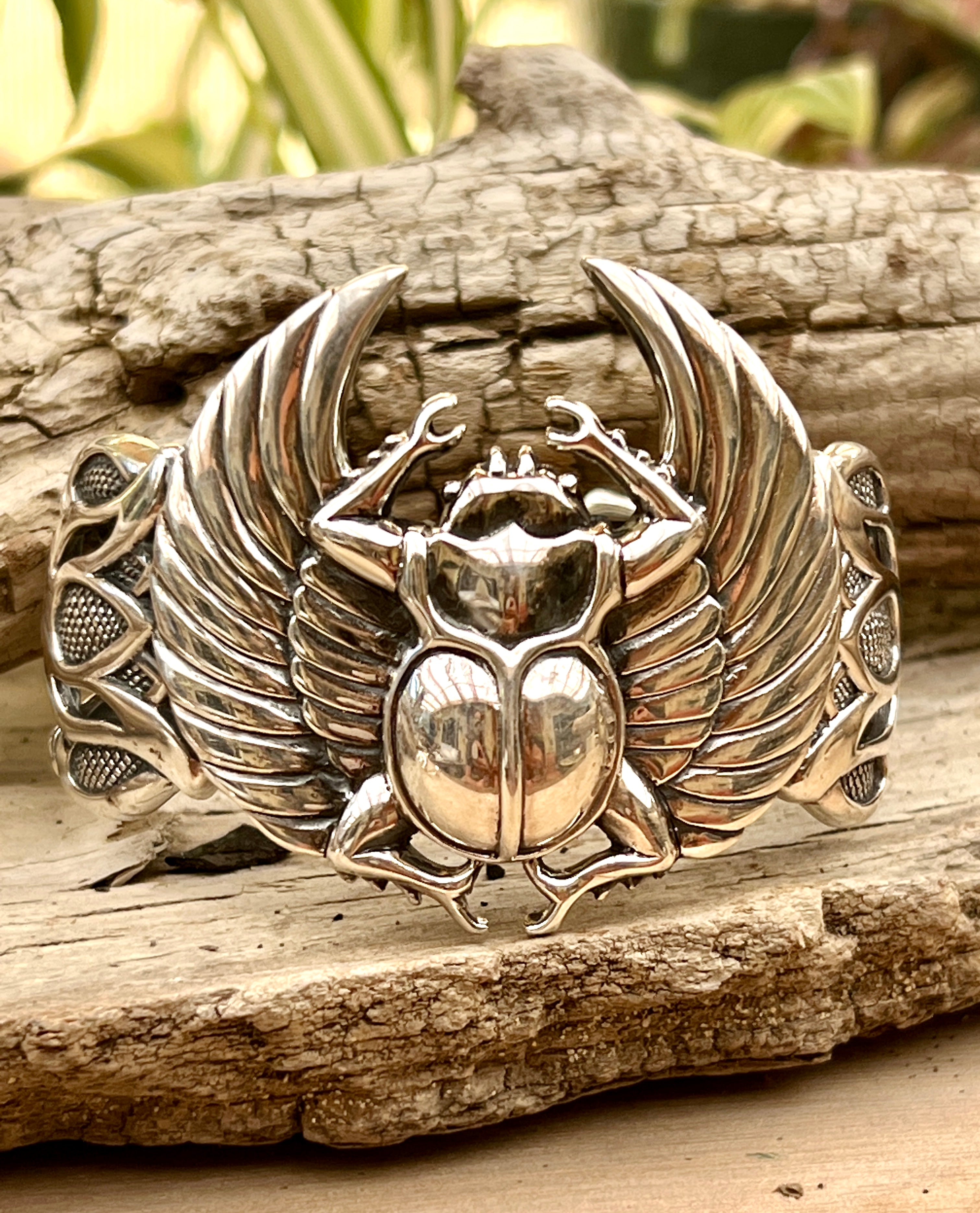 A Super Silver Scarab with Wings Cuff Bracelet with an Egyptian scarab beetle and lotus flowers.
