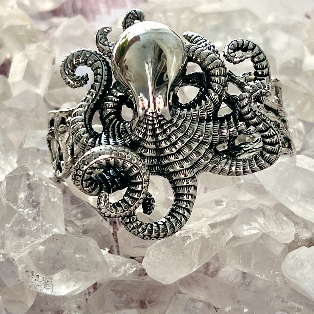 A Super Silver Octopus Statement Bracelet elegantly resting on top of shimmering crystals.