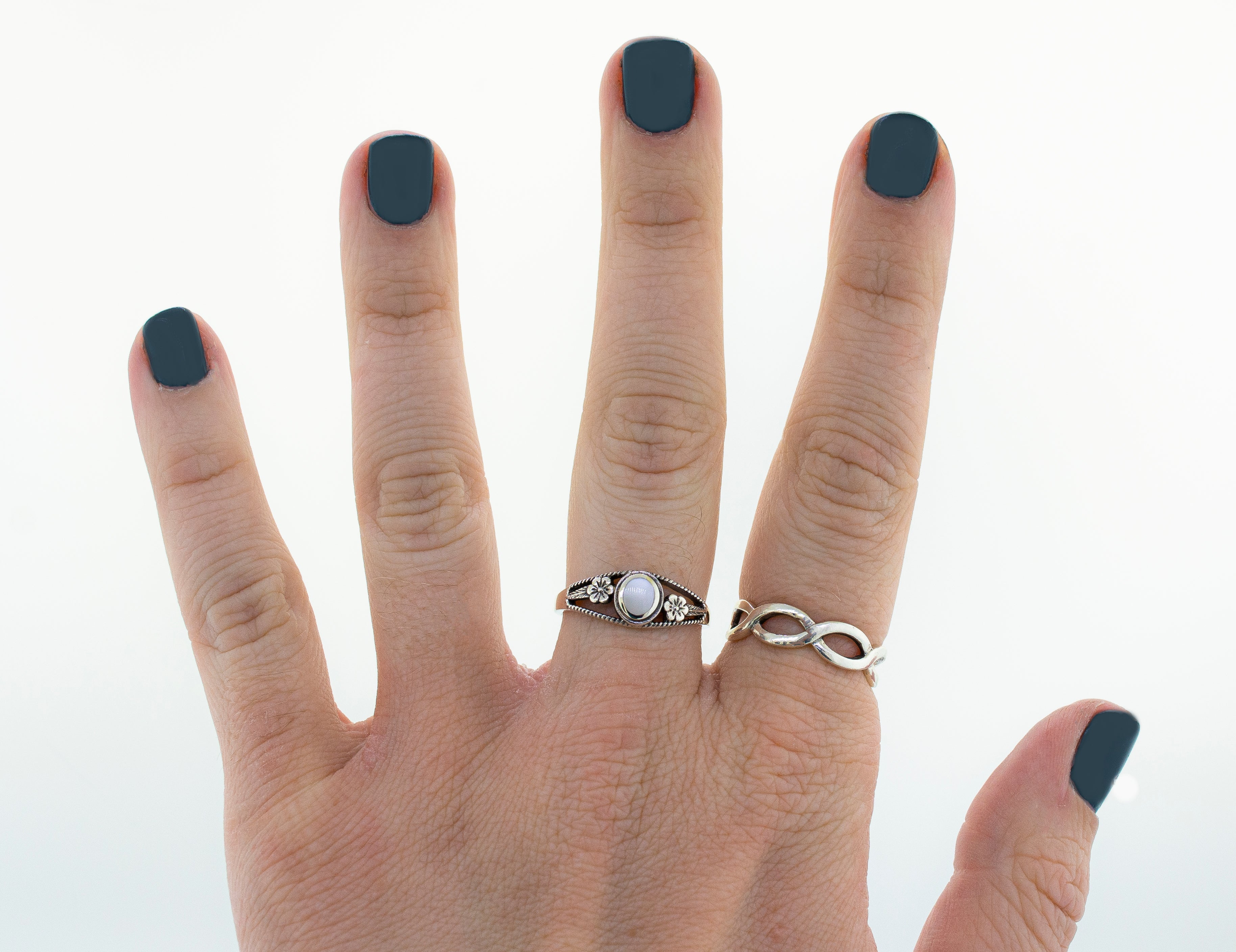 A woman's hand with blue nails adorned by an Inlay Stone Ring with Flower and Rope Design.