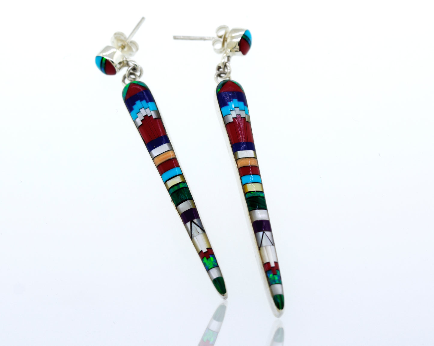 A pair of Super Silver Beautiful Designer Multi-Stone Elongated Teardrop Earrings with colorful inlaid details, crafted from sterling silver, resting on a white surface.