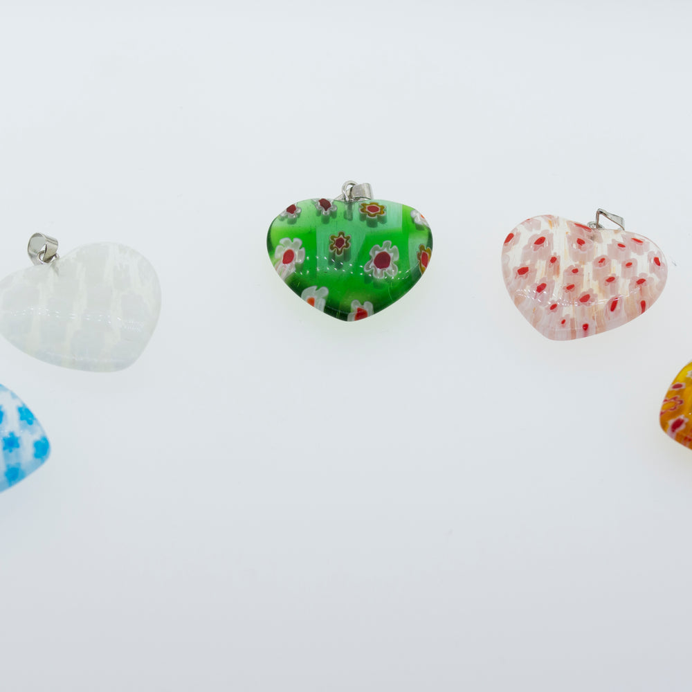 A group of Super Silver translucent resin heart pendants adorned with vibrant flower patterns, showcasing a variety of captivating color schemes, resting on a pristine white surface.