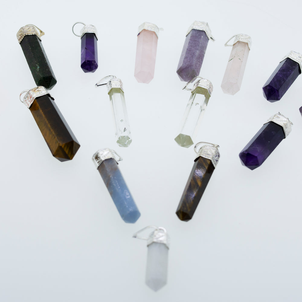 A circle of stones with different colored crystals layered in a Super Silver Raw Stone Obelisk Pendant design.
