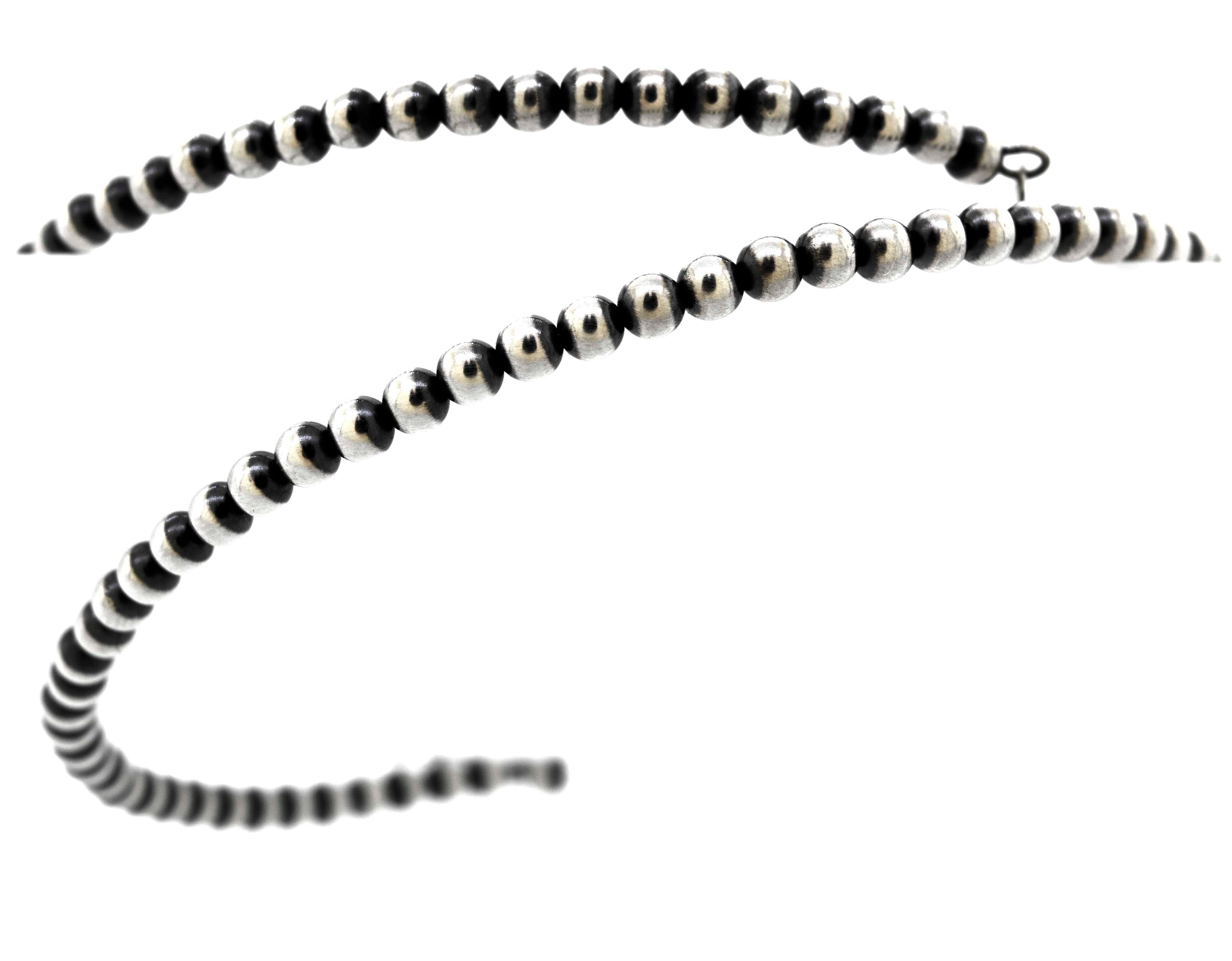 An edgy Super Silver Handcrafted Navajo Pearl Choker on a rustic white background.