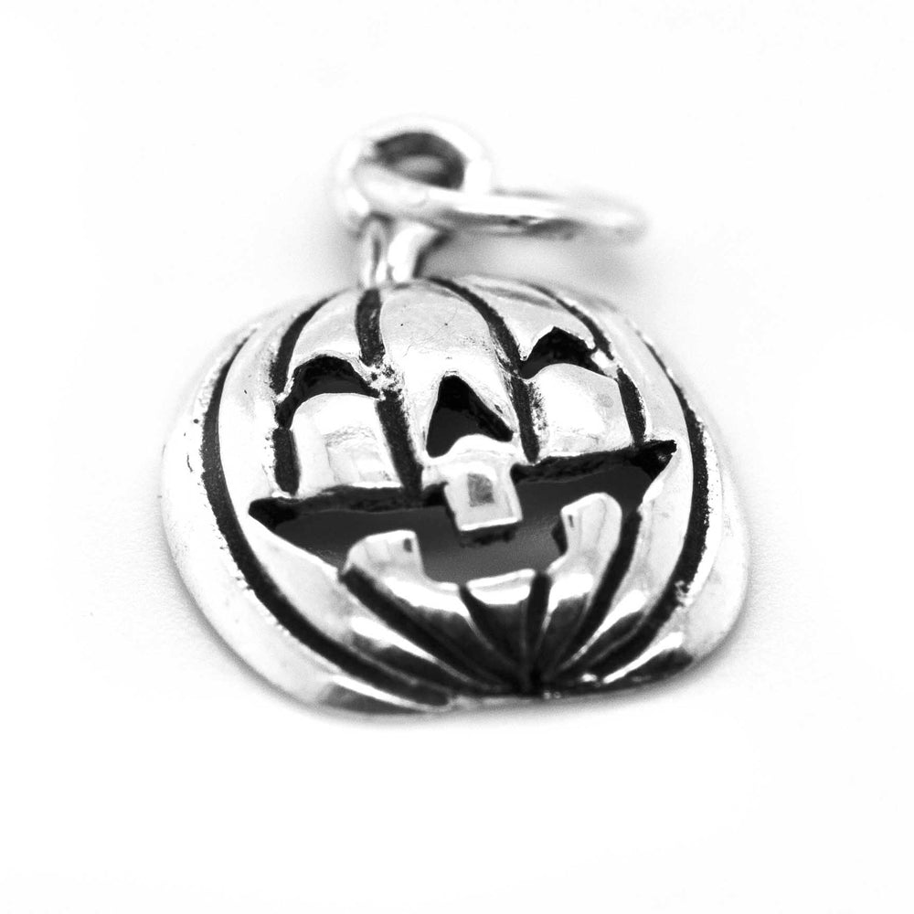 A Halloween-themed, Super Silver Jack O' Lantern Charm on a white surface.