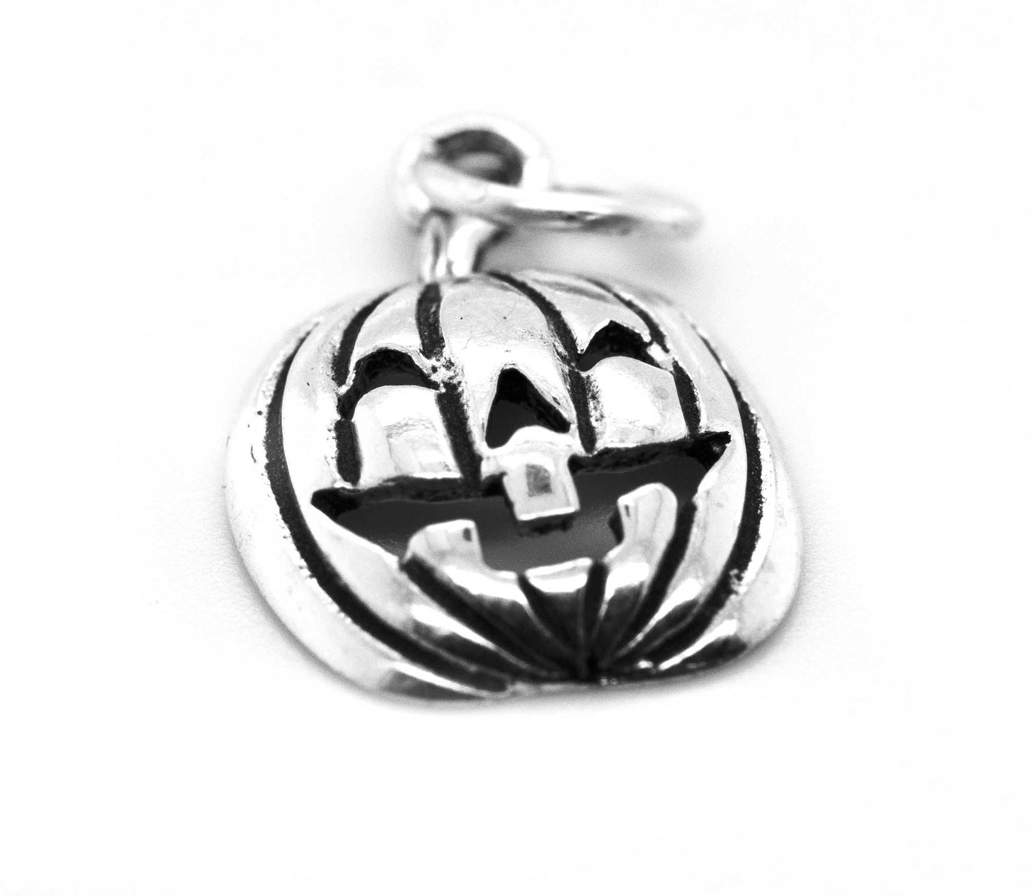 A Halloween-themed, Super Silver Jack O' Lantern Charm on a white surface.