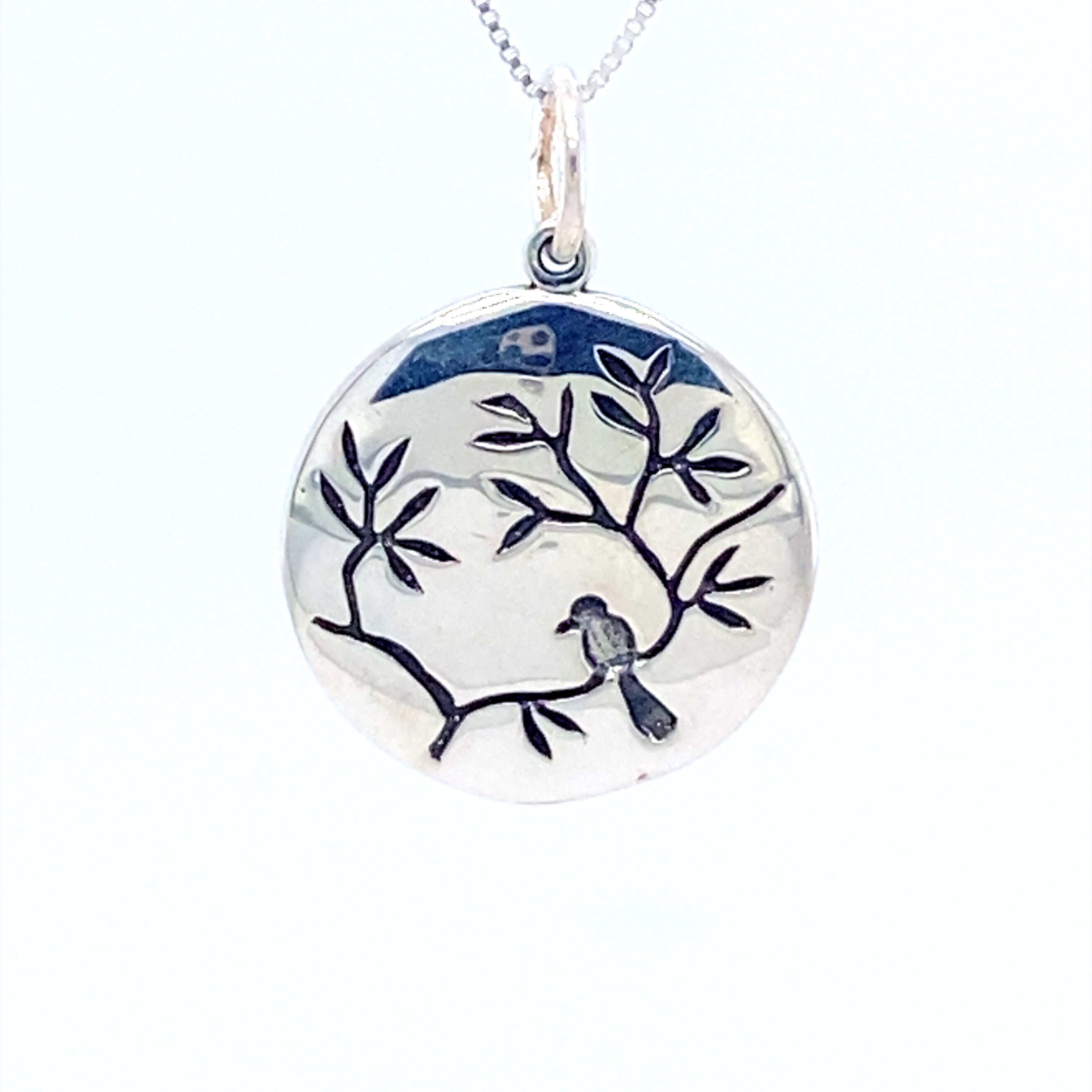 A Super Silver small circle nature charm with a bird on a cherry blossom branch.