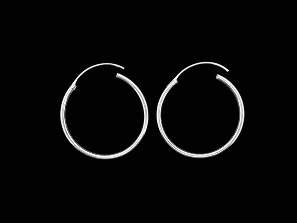 A pair of Super Silver Infinity Hoop 2mm x 30mm sterling silver hoop earrings on a black background.
