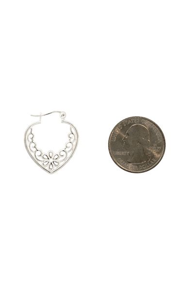 A silver coin next to a Super Silver Heart Shaped Hoop with Filigree and a Flower earring made of Sterling Silver.
