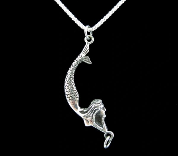 A Super Silver Lounging Mermaid Pendant necklace hanging from a chain on a black background.