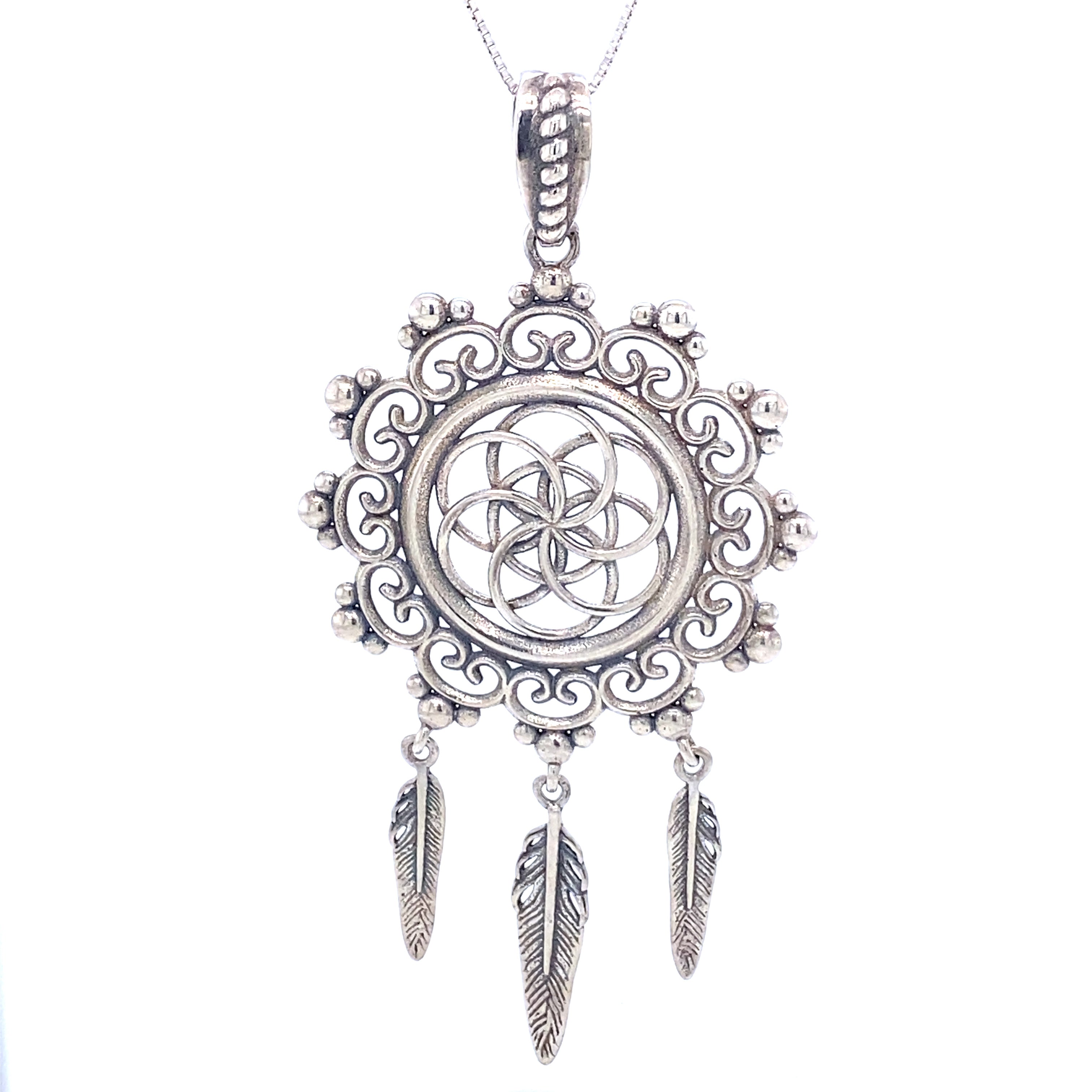 The Flower of Life Mandala Dreamcatcher Pendant features an intricate circular design with a decorative border and three feather charms, evoking the look of a dreamcatcher and suspended gracefully on a chain.