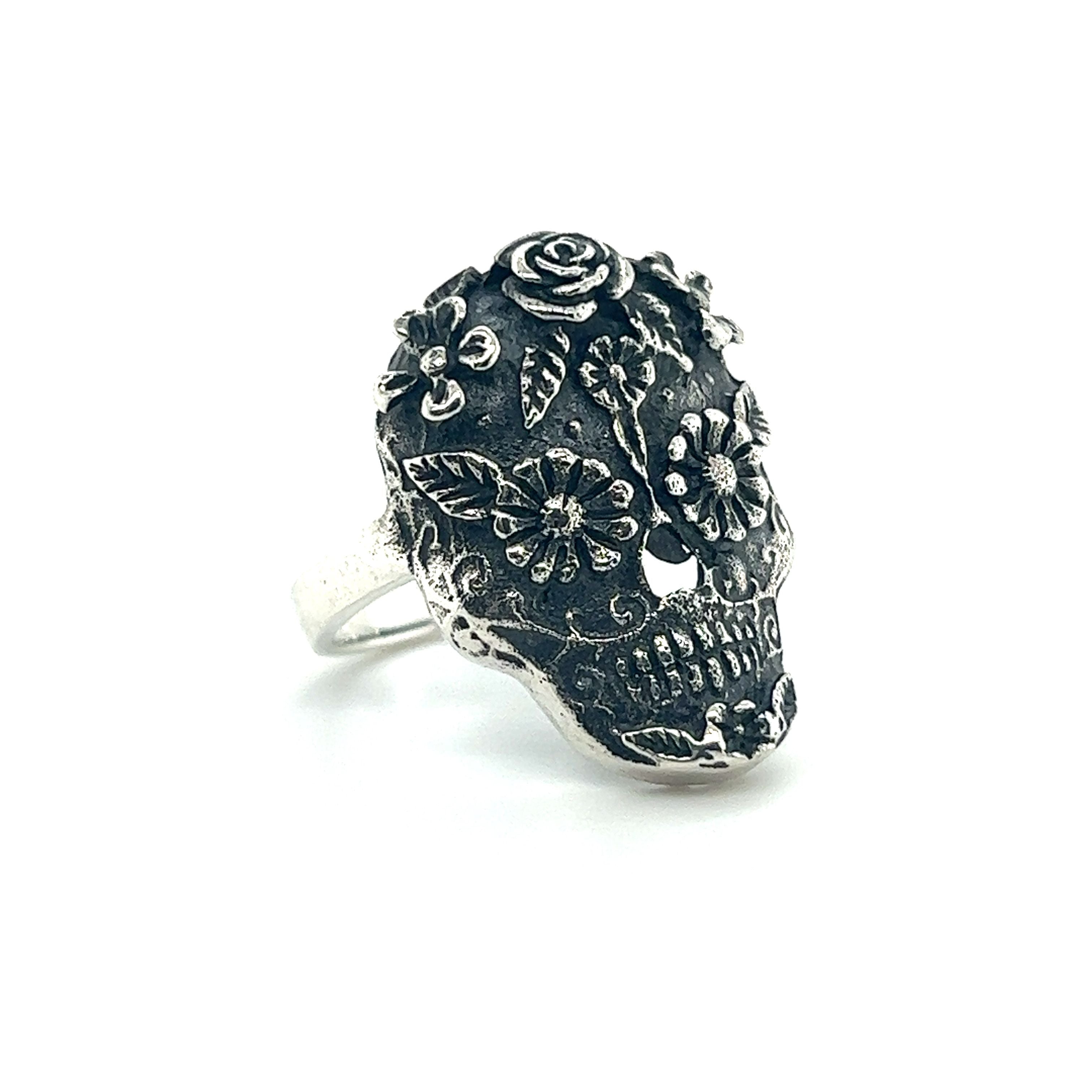 An intricate sugar skull ring on a white background.